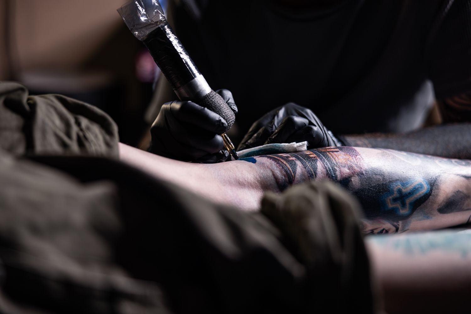 Close-up shot of a tattoo machine in action during a session.
