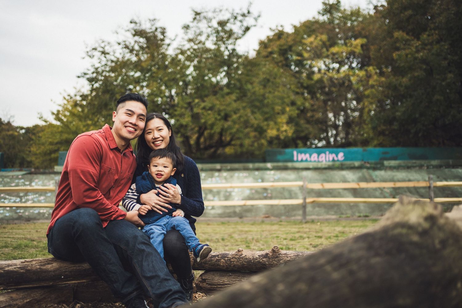 People enjoying a relaxing moment in a park with wooden fence and trees.