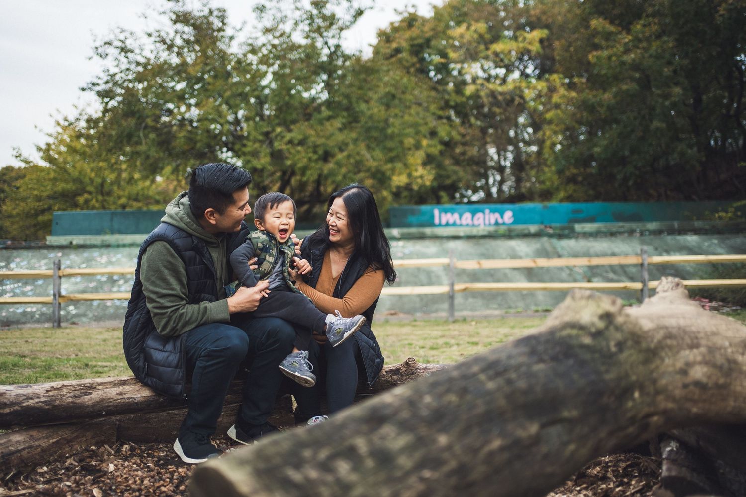 Casual outdoor family gathering on natural rock formations in park setting.