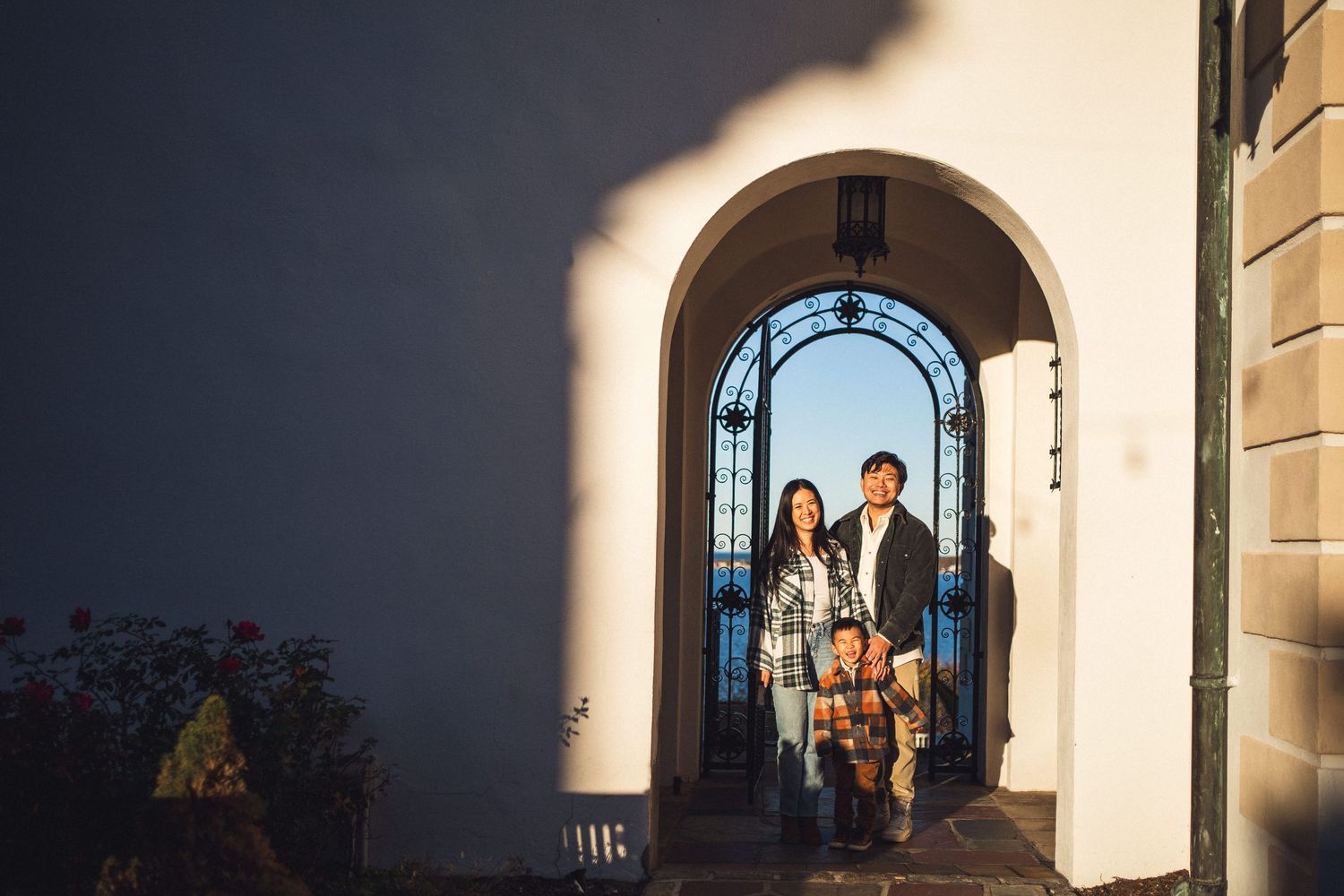 Family standing in arched doorway with dramatic lighting and shadows.
