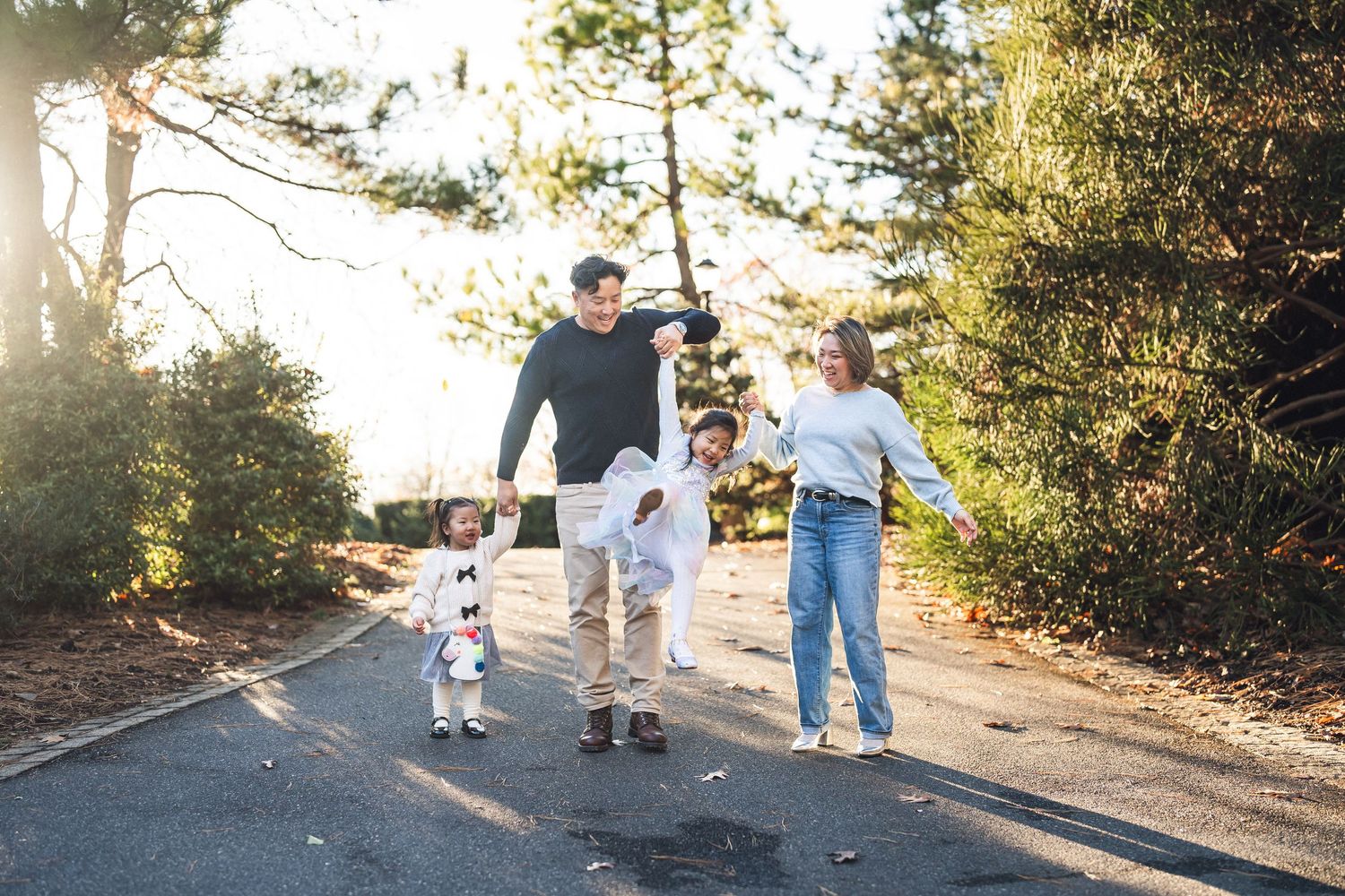 Family walking together on a path during golden hour with trees in background in Clark Botanic