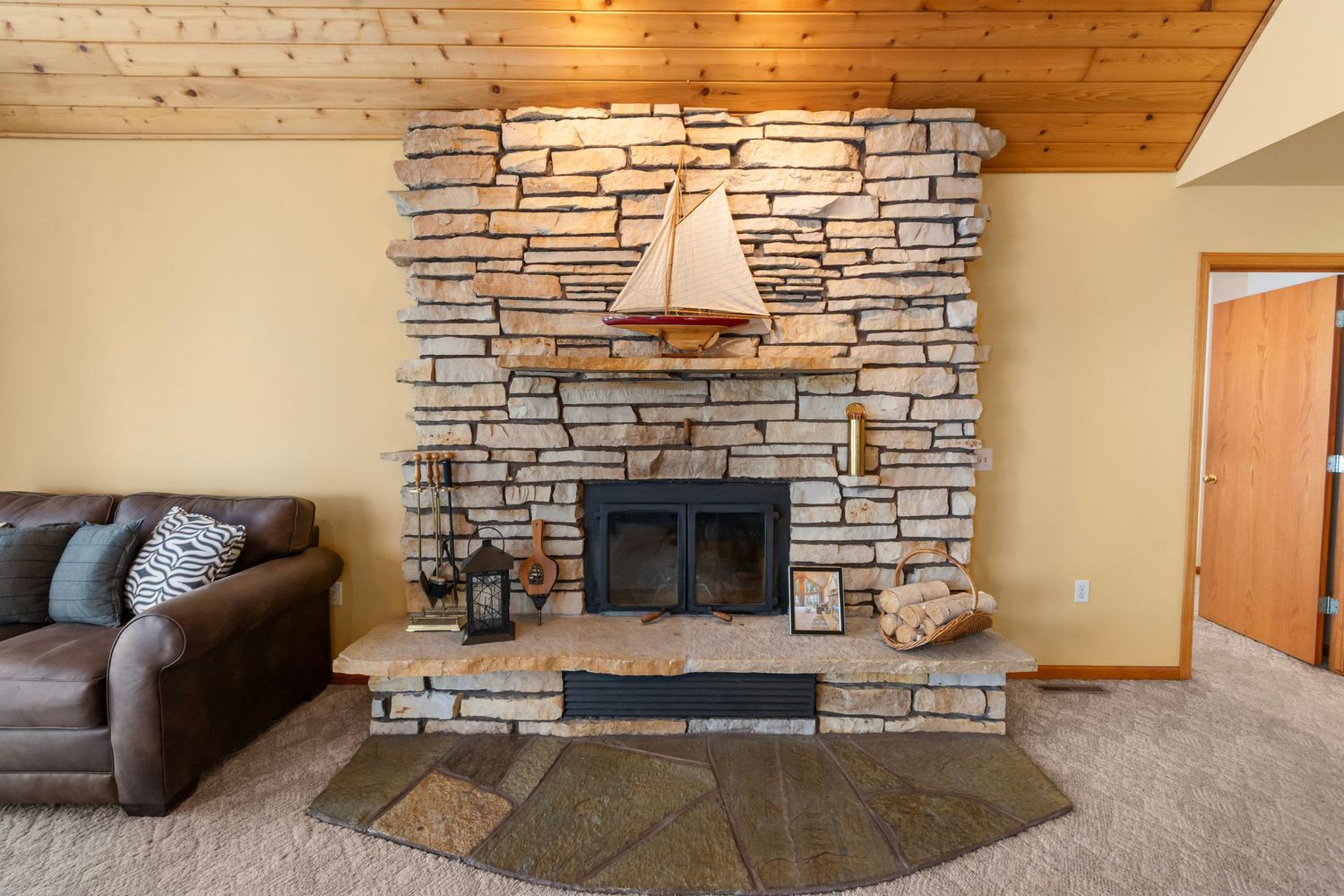 Stone fireplace with nautical decor and comfortable seating in a cozy living space.