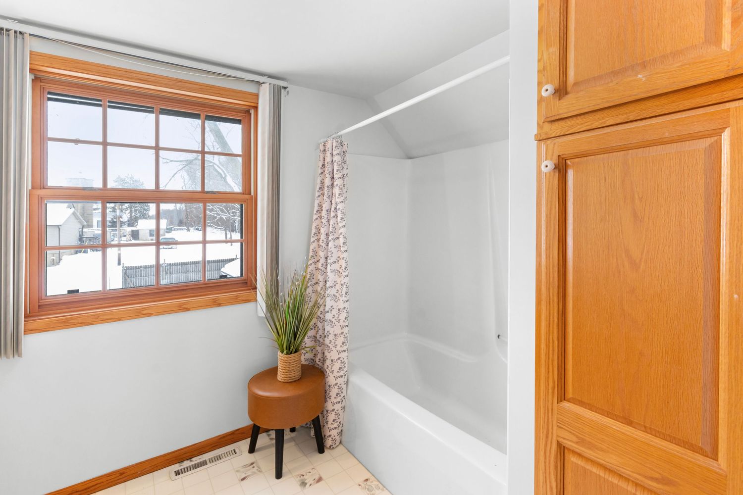 White hallway interior with wooden trim and doors featuring natural light from multiple windows.