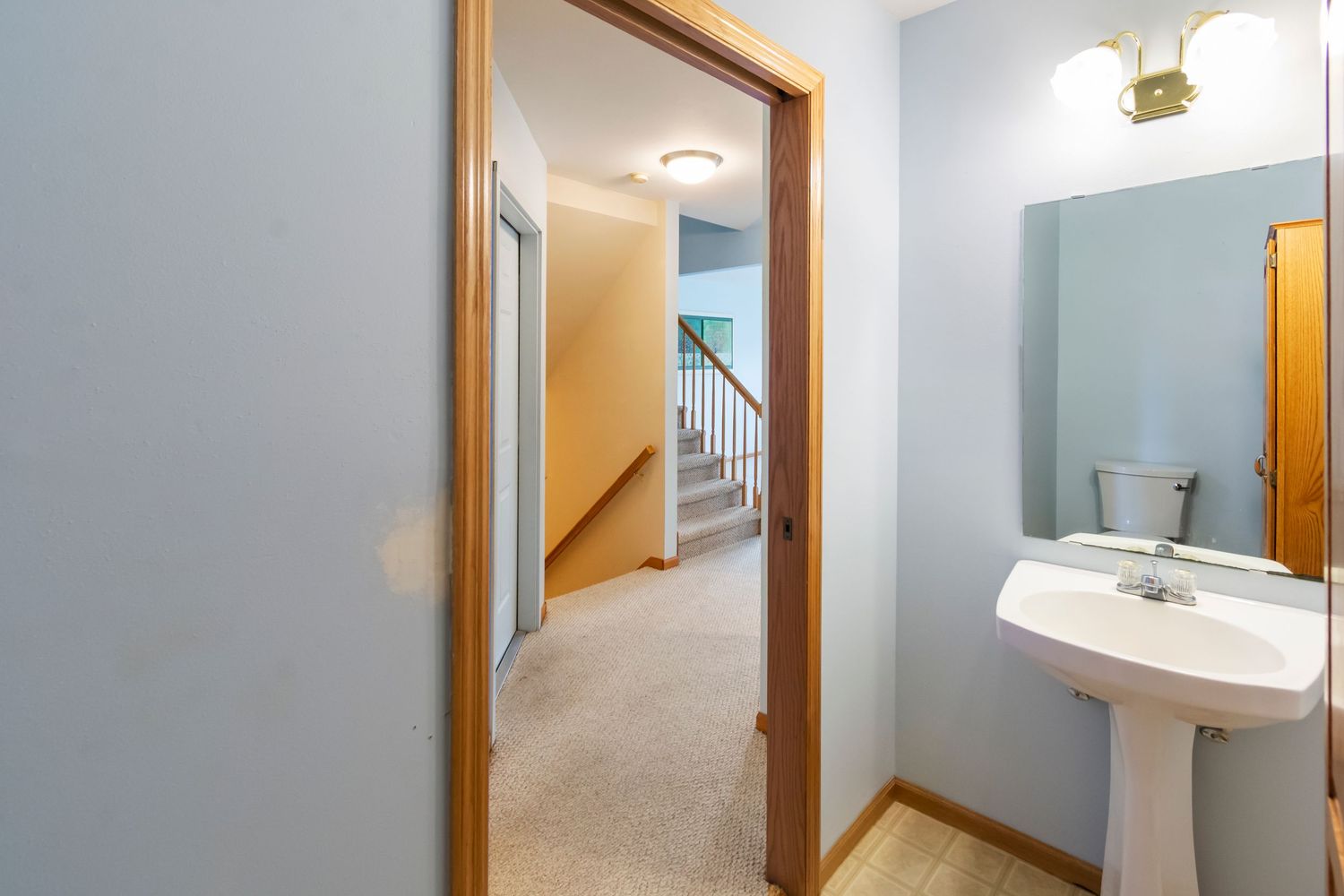 Hallway view showing multiple wooden doors and light blue painted walls.