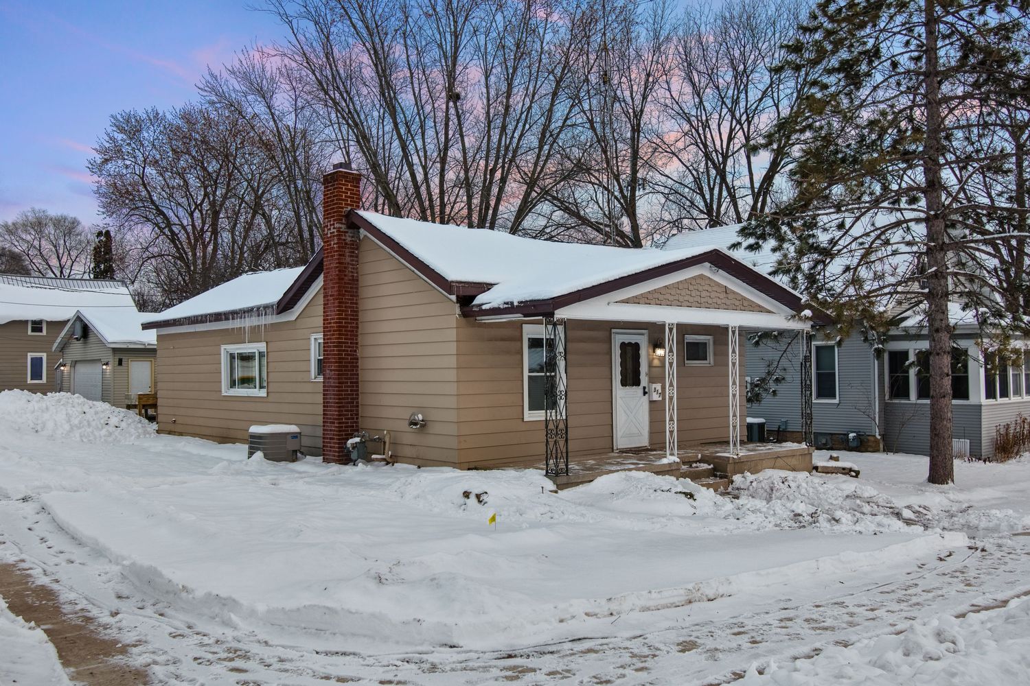 Snow covered suburban neighborhood with houses and driveways on a winter day.