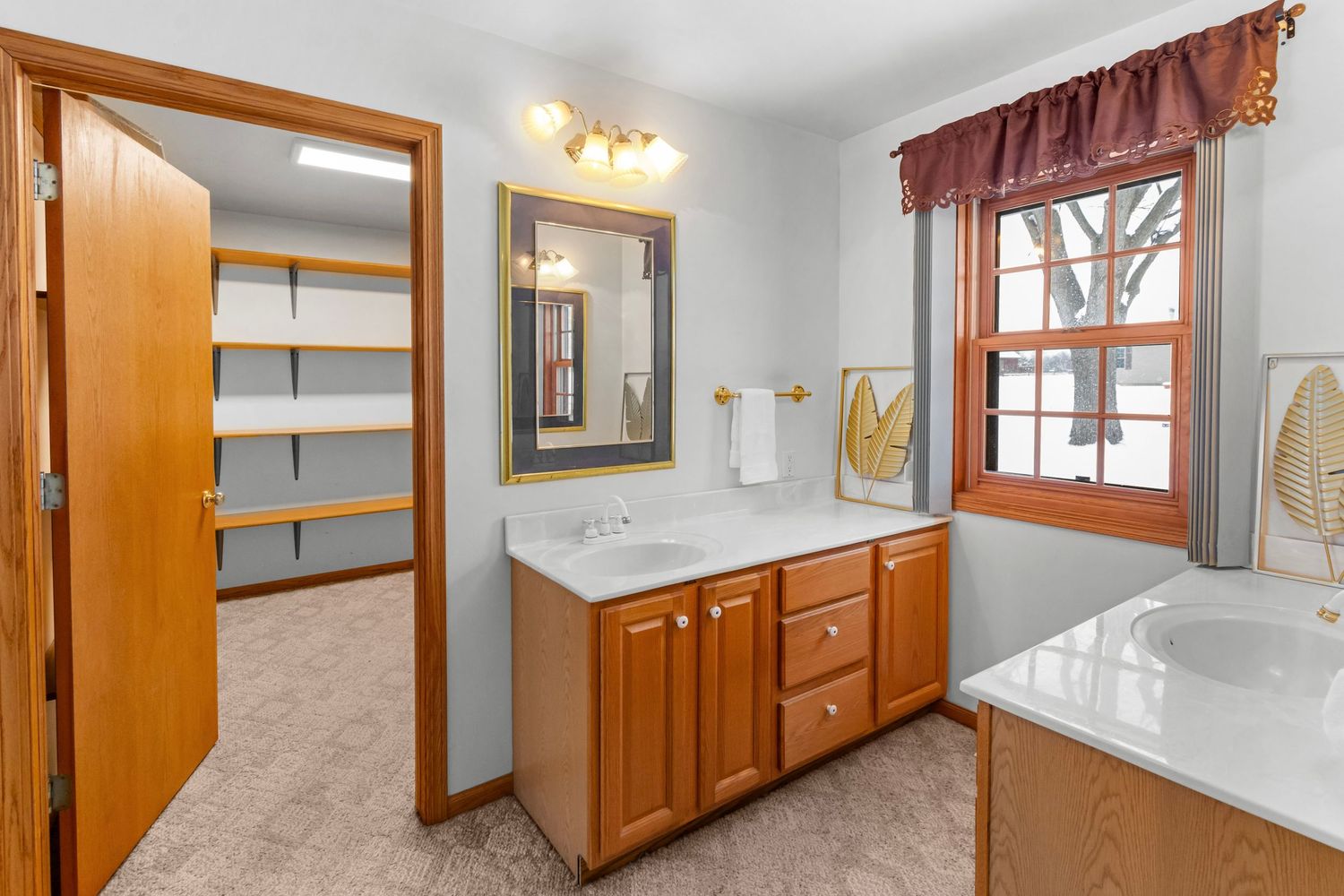 Modern bathroom featuring white countertops, wooden cabinets, and clean design elements.