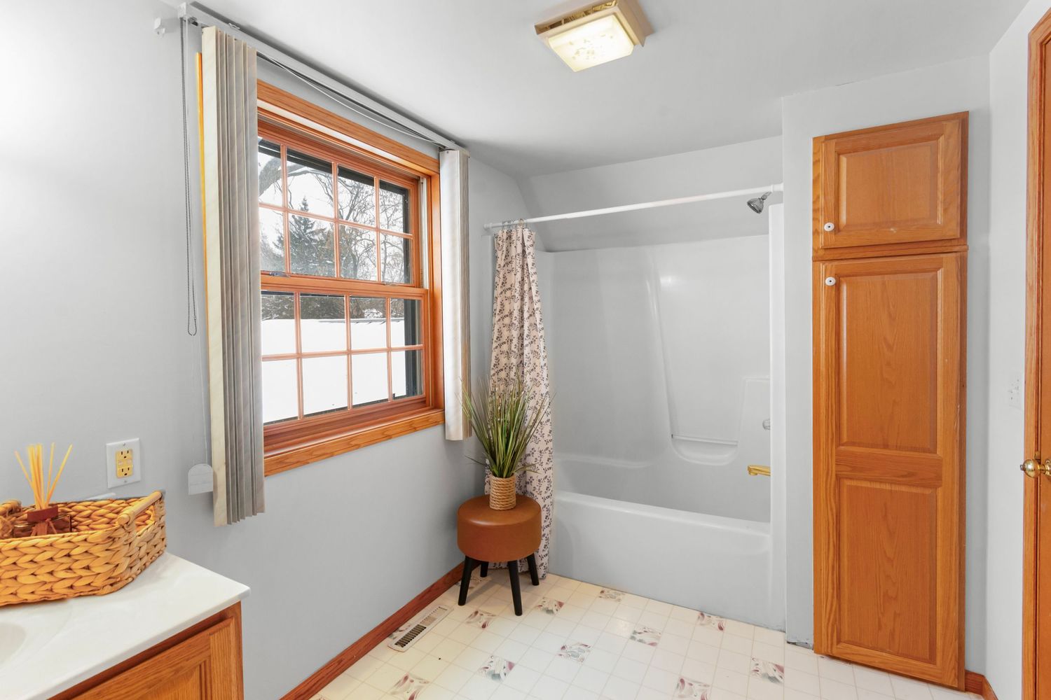 Bright basement room with white walls, wood trim, small windows and utility door access.