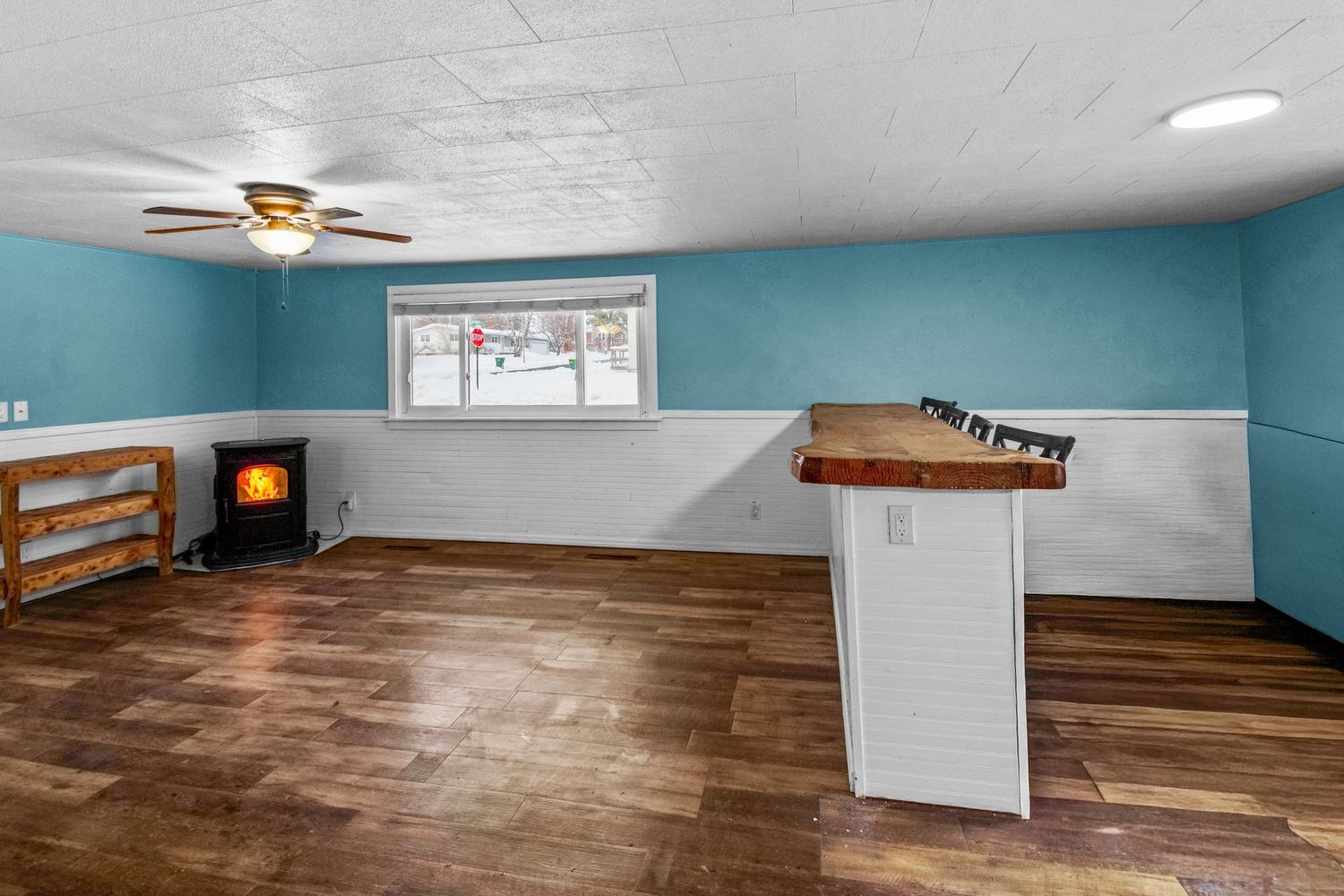 Empty room with hardwood floors, turquoise walls, and ceiling fan showing different angles of the space.