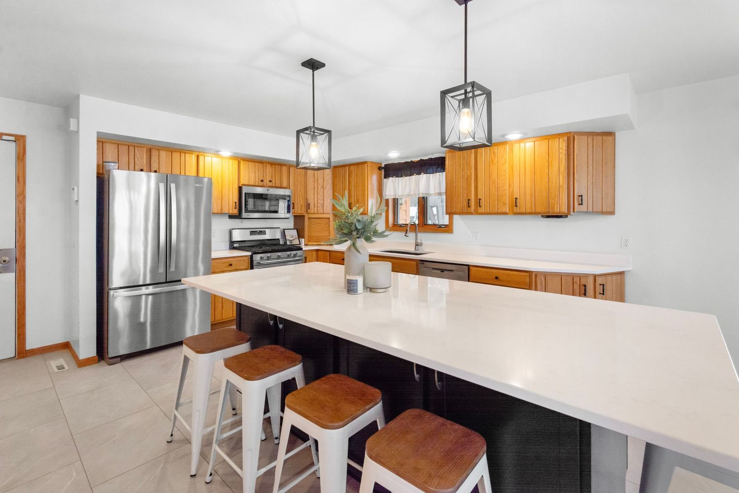 Open concept kitchen and dining area featuring white quartz counters and honey-colored wood cabinetry.