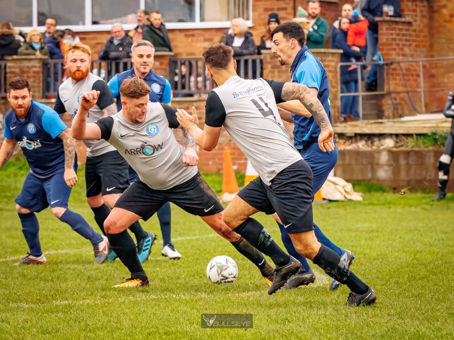 Rugby players practice dynamic stretching exercises on a grass field before a match.