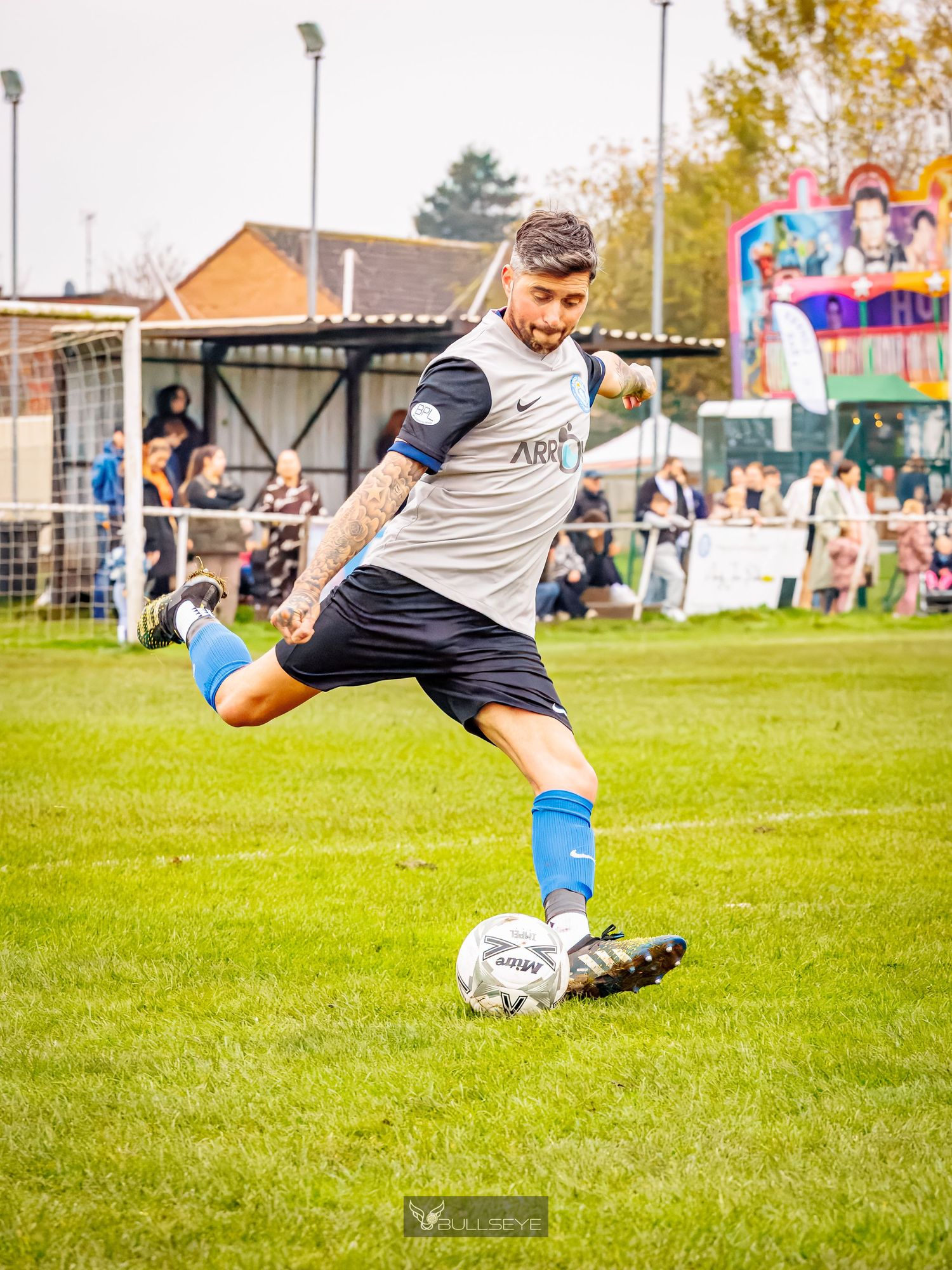 Soccer player in mid-air executing a dramatic diving save on a grass field during a match.