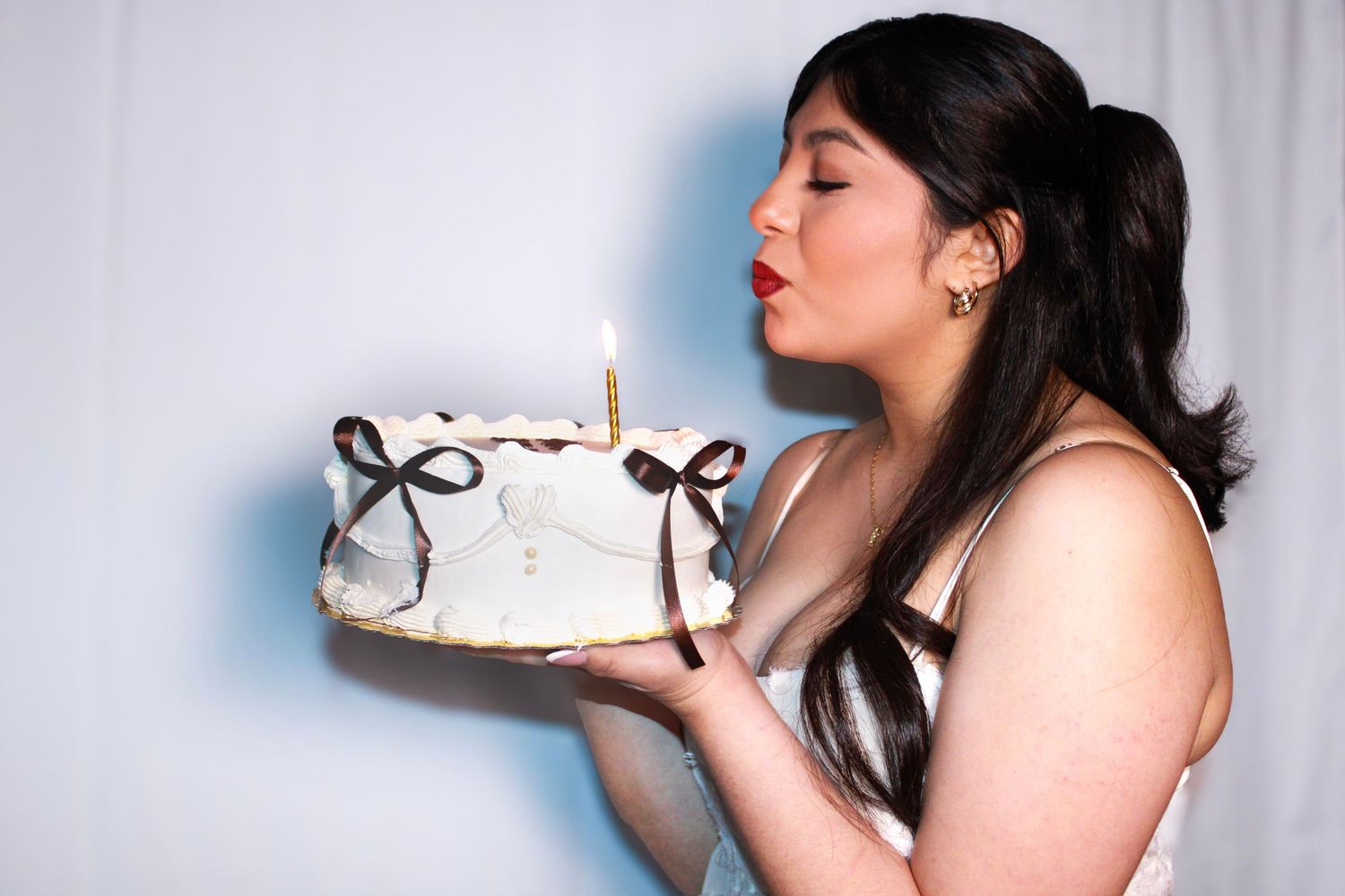 Someone wearing a white dress takes a bite of cake in a series of celebratory photos.