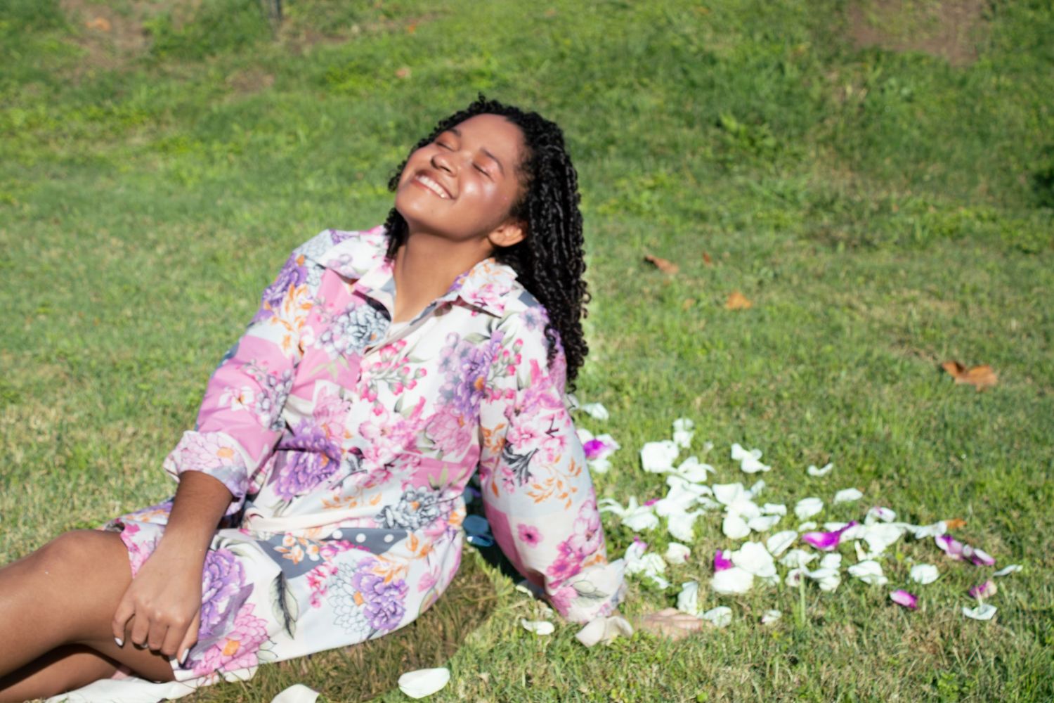 A dreamy garden scene with scattered flower petals on grass.