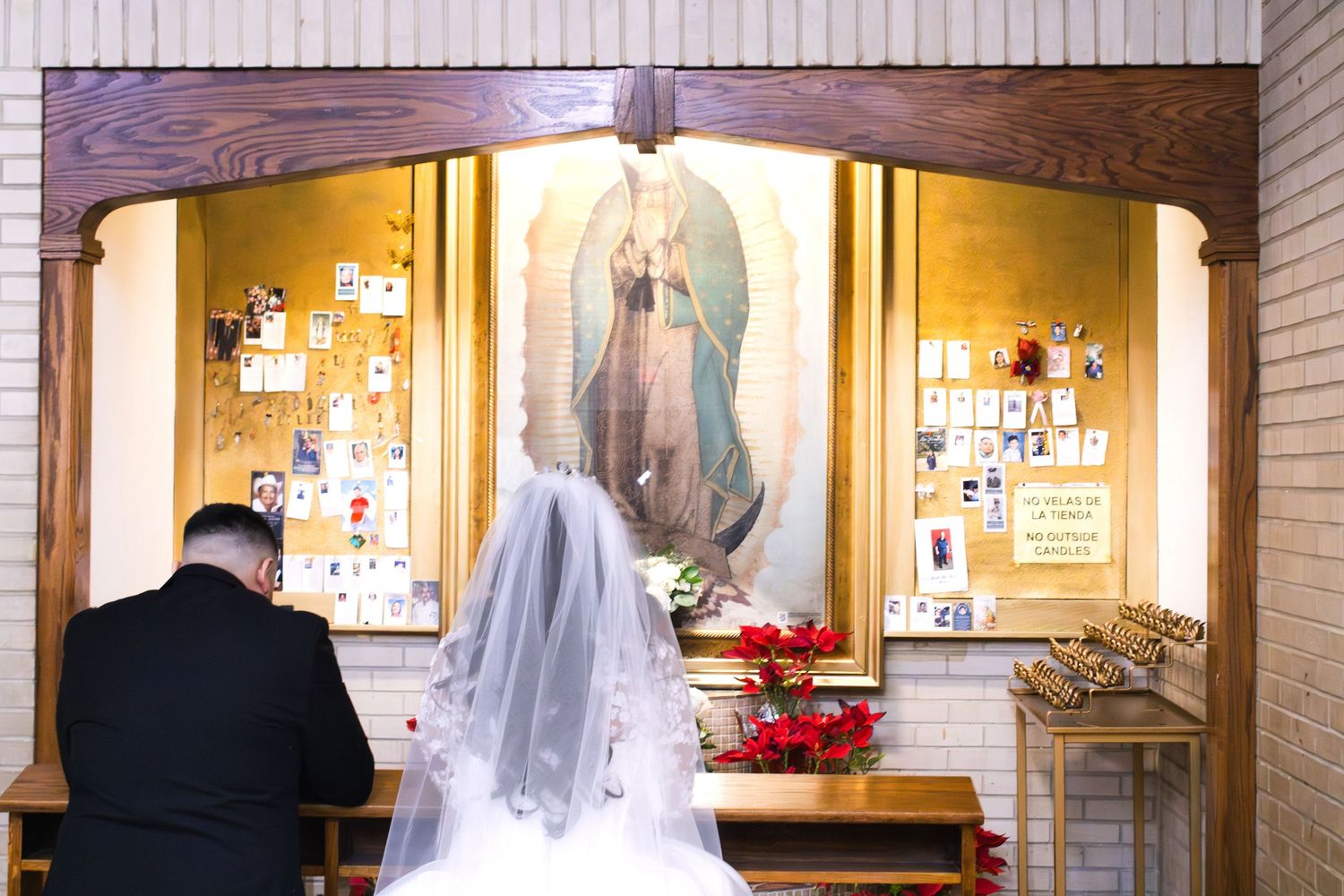 A wedding scene in a church with a religious shrine and candles.
