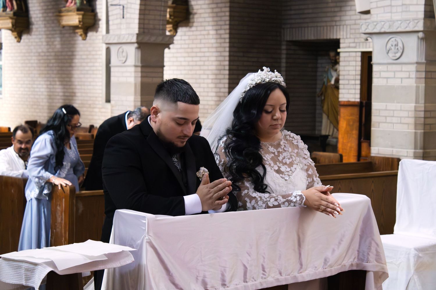 A wedding ceremony in a church with a couple signing documents at a table.
