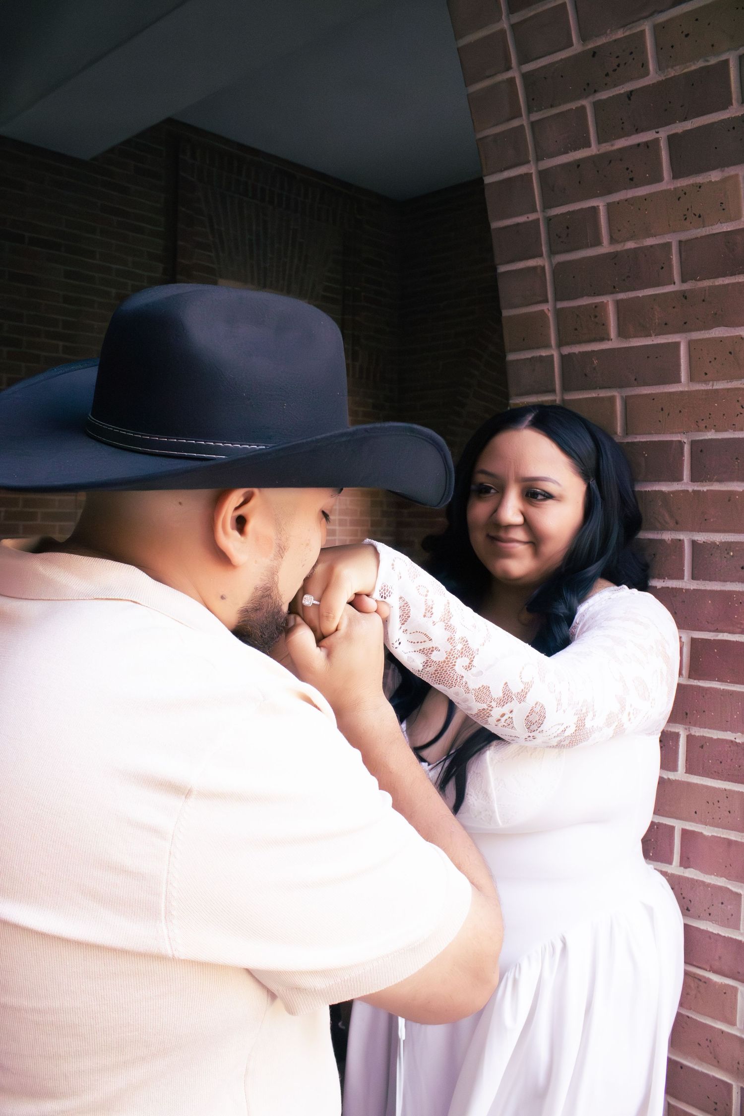 A romantic couple embracing against a brick wall background in multiple shots.