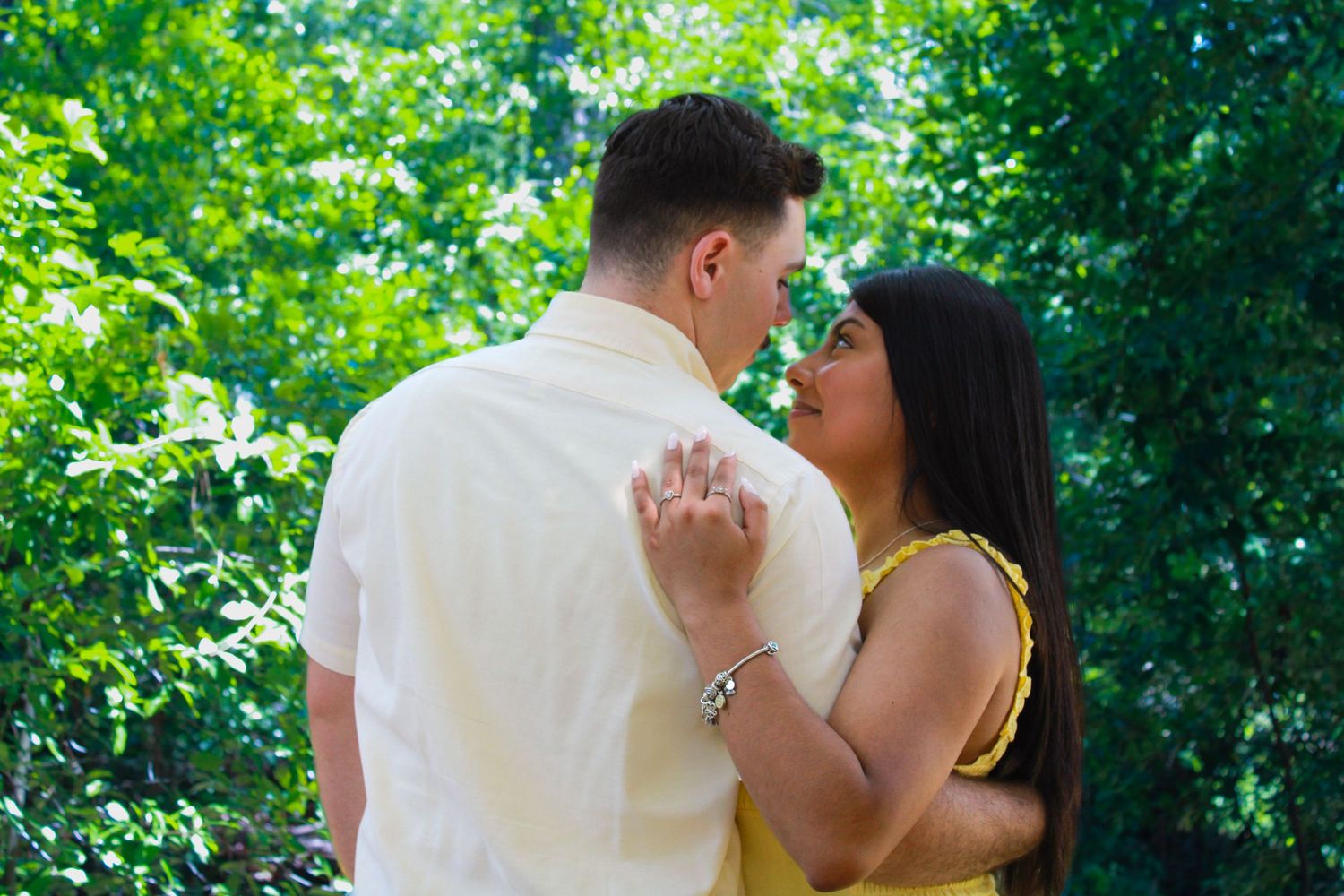 Romantic dance sequence captured in a garden with sunlit greenery in the background.