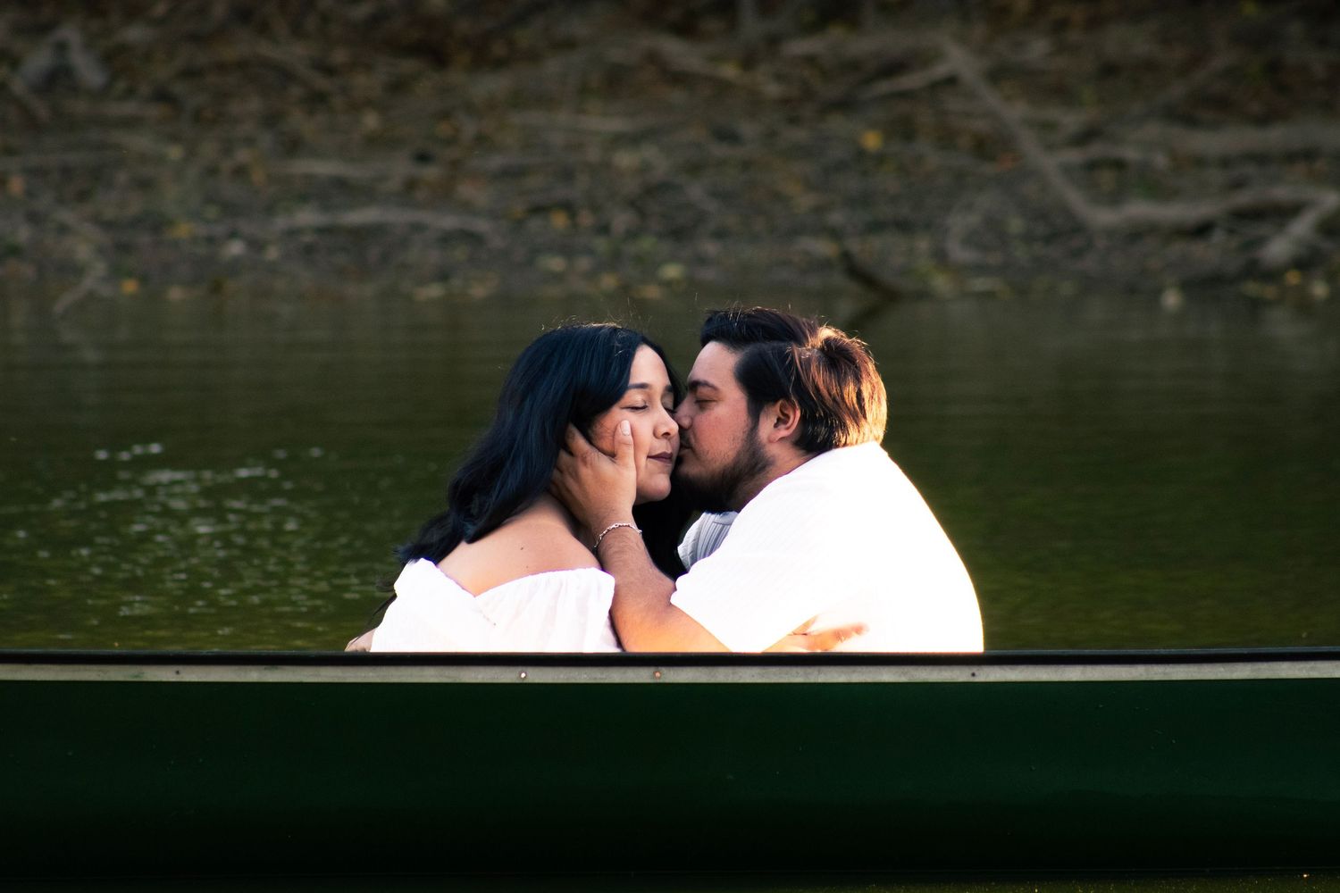 A romantic couple sharing intimate moments on a boat near sunset.