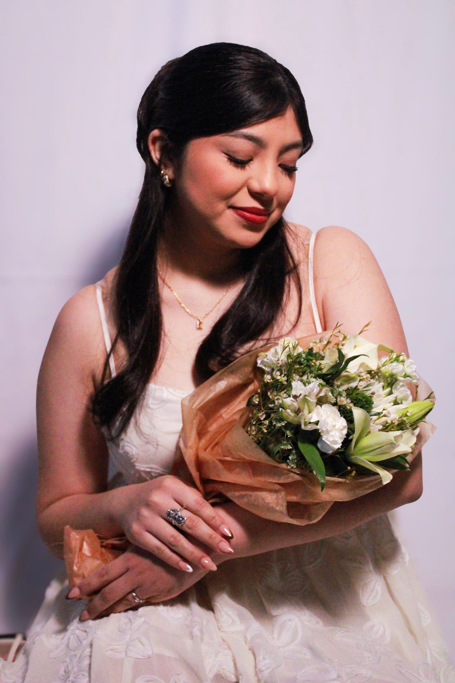 White dress and floral bouquet in romantic portrait series against neutral background.