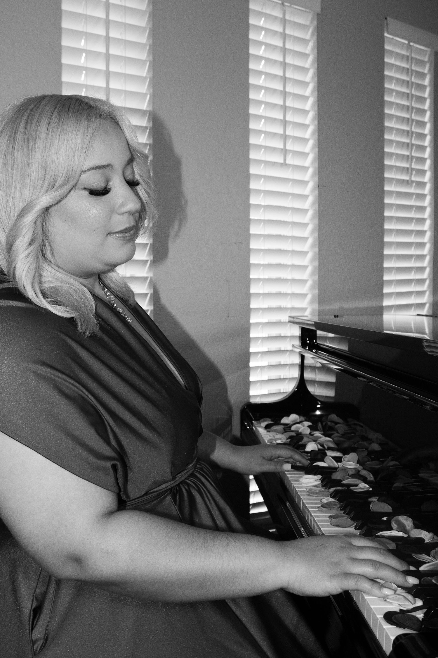 Black and white photos of someone playing piano with dramatic lighting.