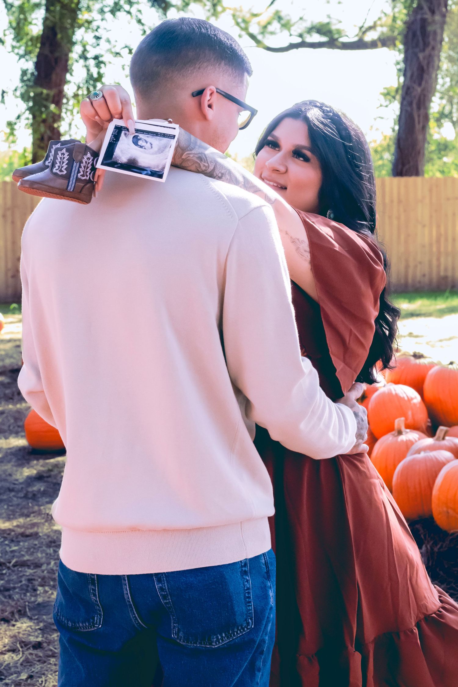 Group gathering near pumpkins in casual attire during an autumn photoshoot.