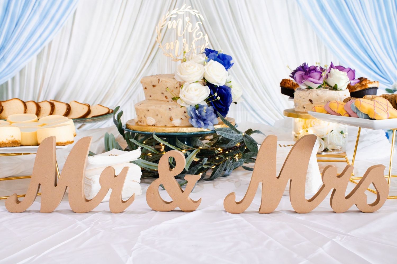 Wedding decor details showing white drapery and 'Mr & Mrs' signage at an elegant reception venue.
