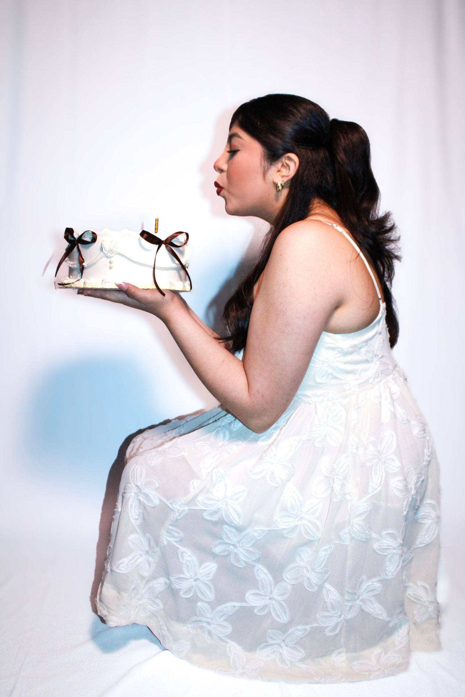 Portrait series showing playful poses in a white lace dress.