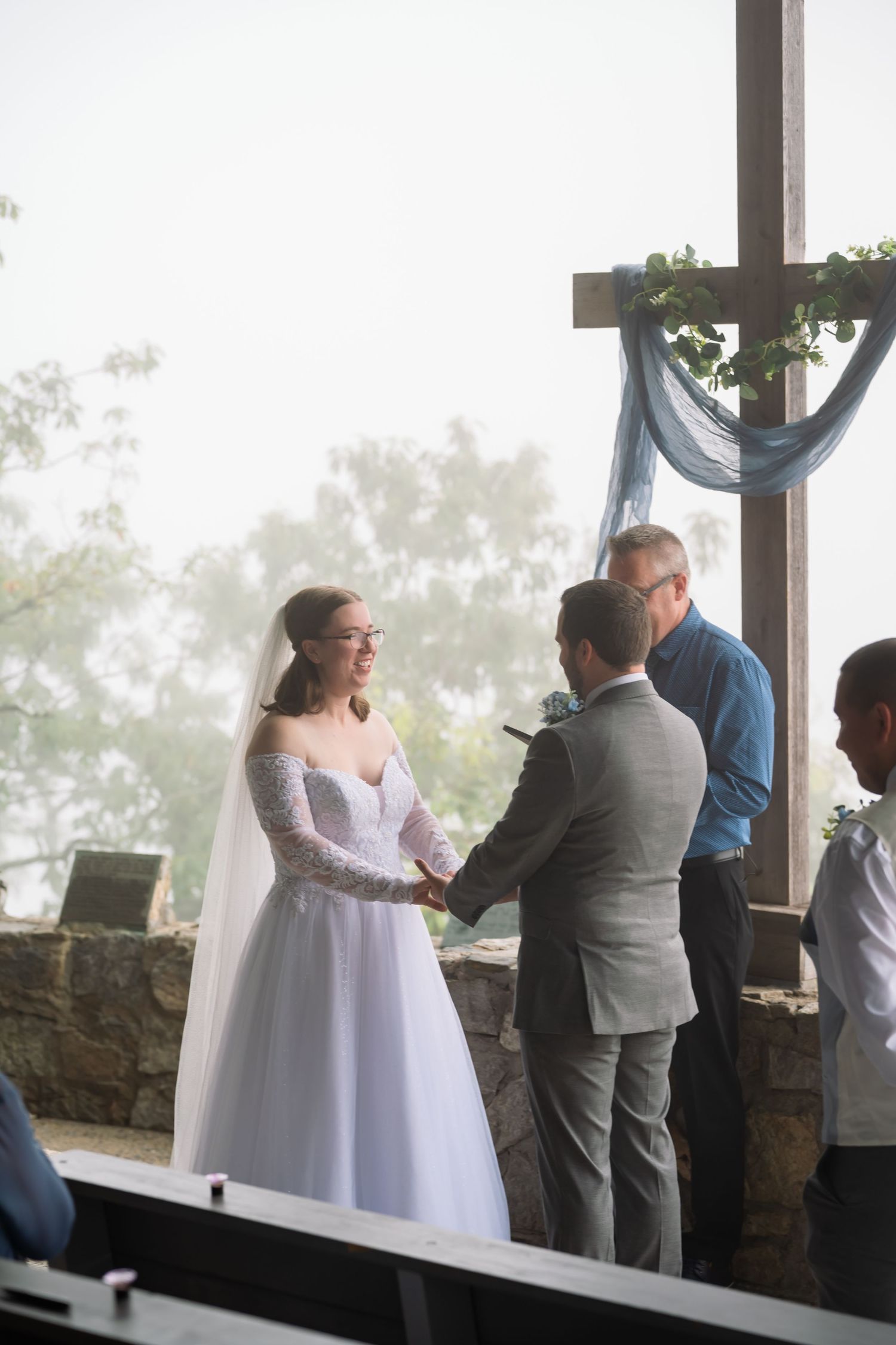 A couple exchanges vows during a misty mountain wedding ceremony in an open-air pavilion.