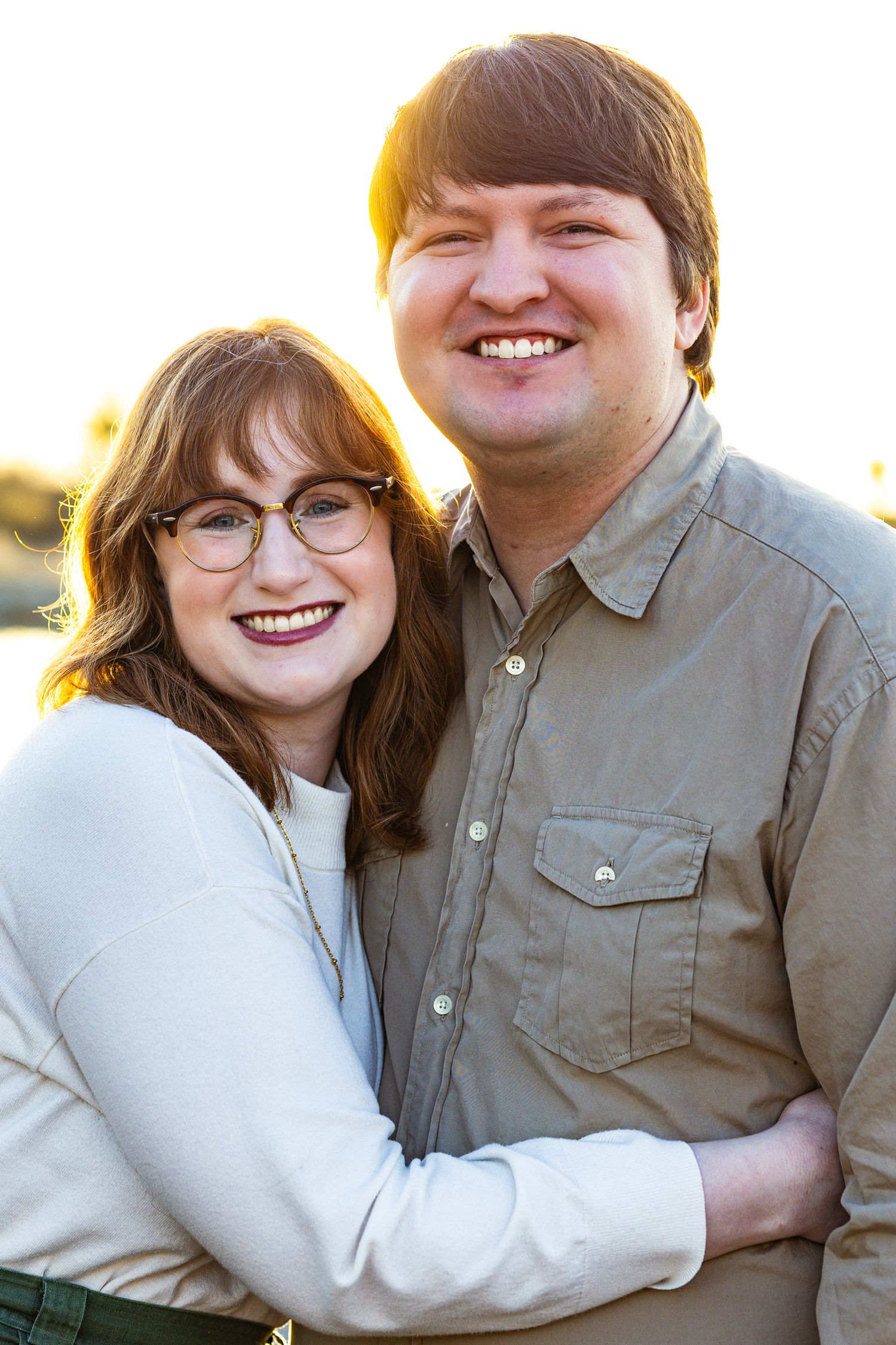 A couple wearing casual attire share warm smiles while embracing in a series of outdoor portrait photos.