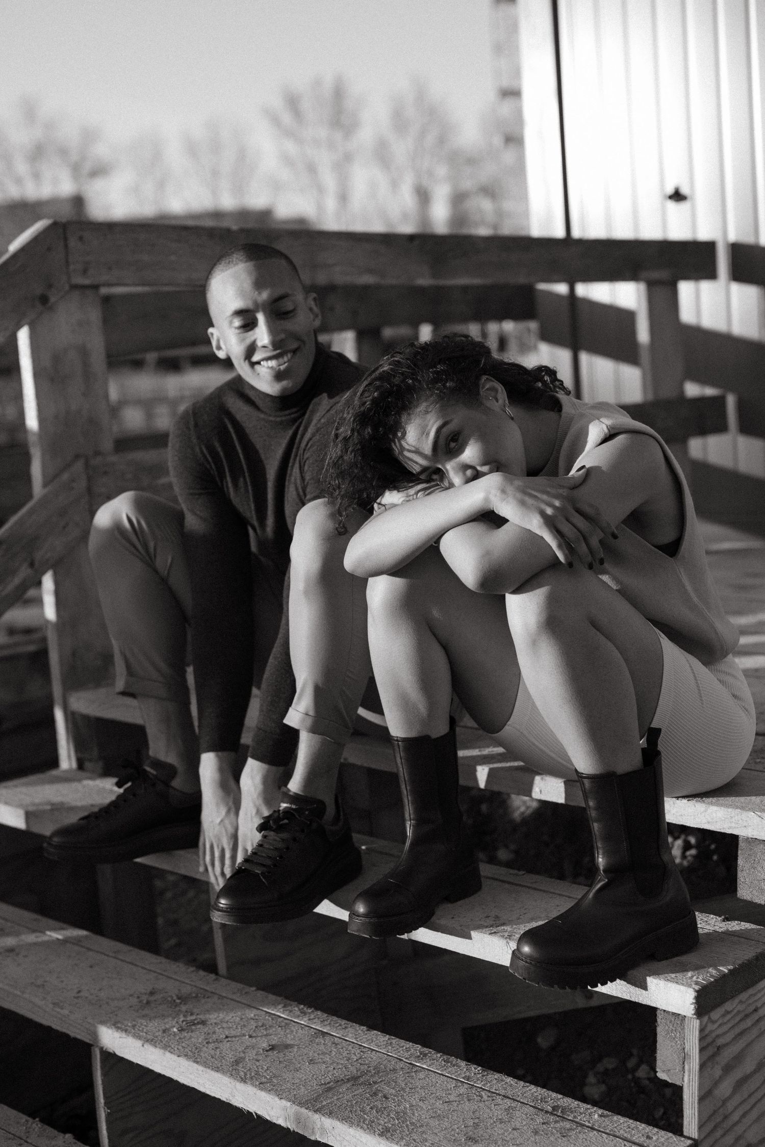 Black and white photo series of people lounging on wooden benches.
