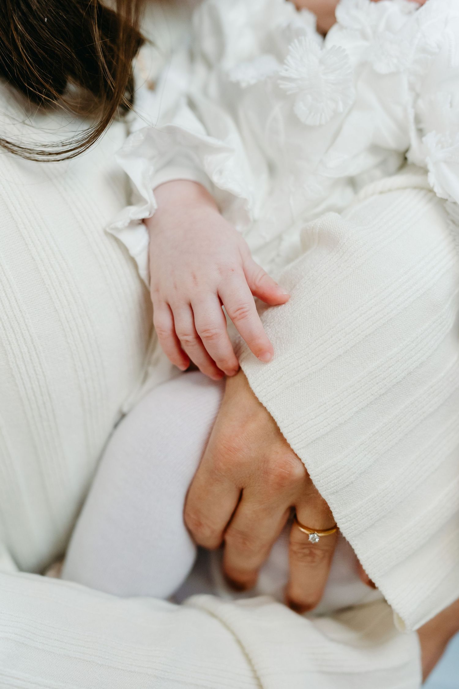 Close-up detail shots of hands with rings against white textured fabric.