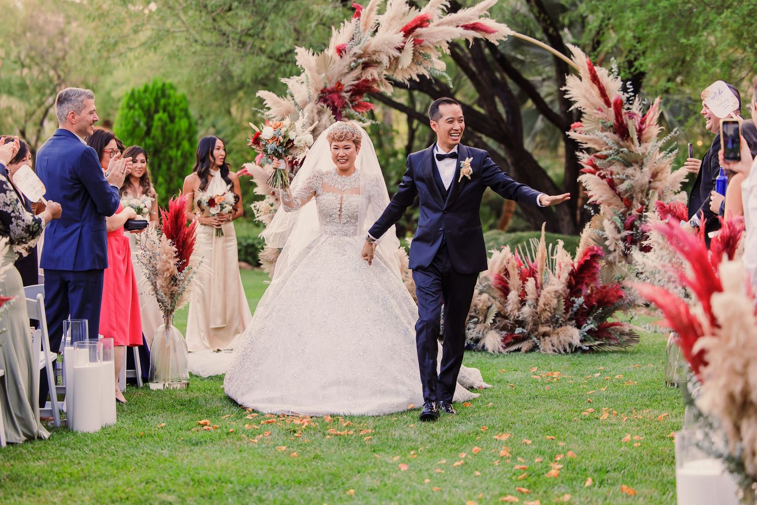 Outdoor wedding ceremony surrounded by pink floral arrangements and greenery at the JW Marriott in Las Vegas