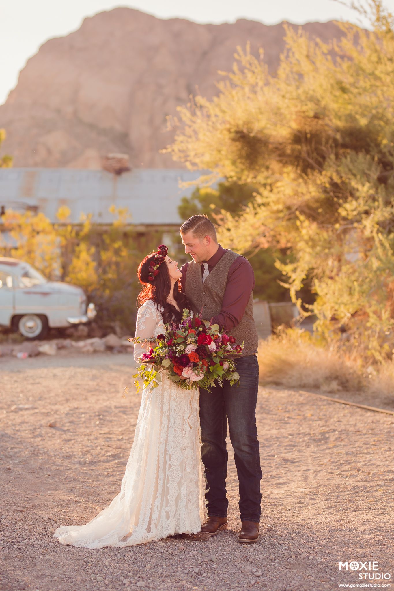 A romantic desert photoshoot at sunset with warm golden light and mountains in the background.