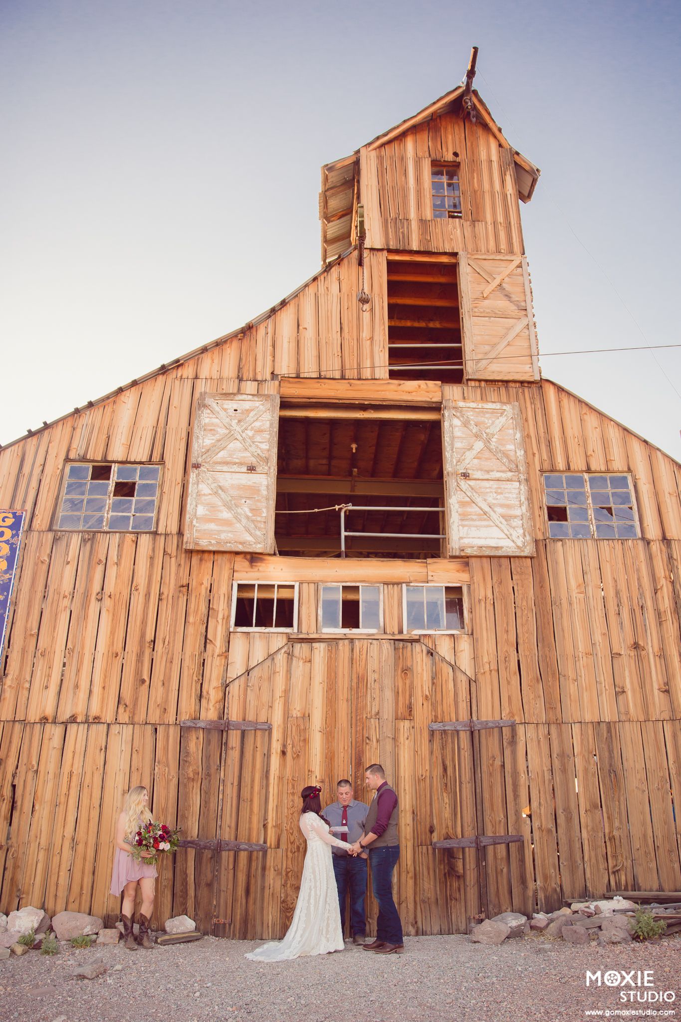A rustic wooden barn with multiple panels shown in a sequence of five similar angles during a sunset ceremony.