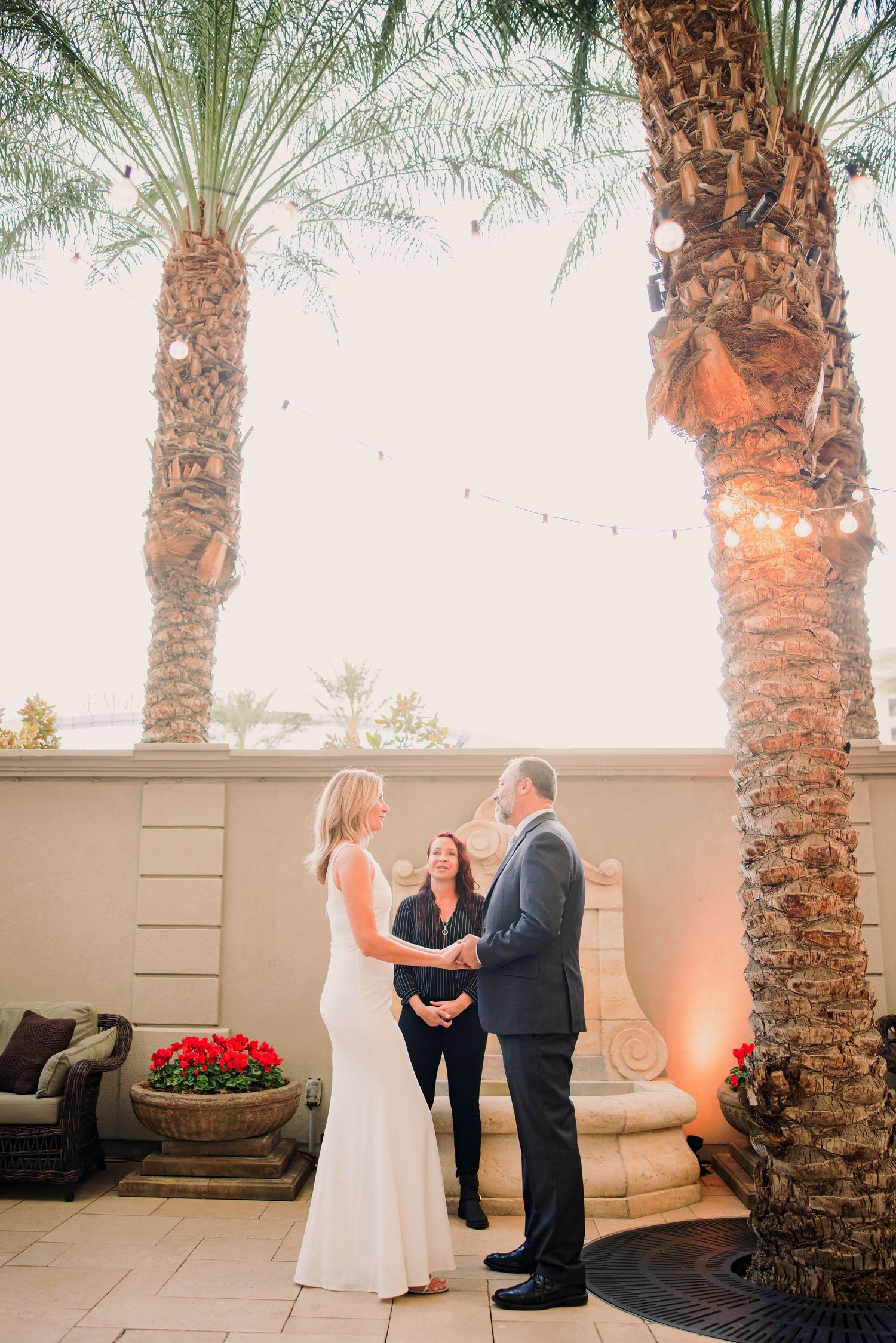 A romantic first dance sequence between a couple on a patio surrounded by palm trees at sunset.