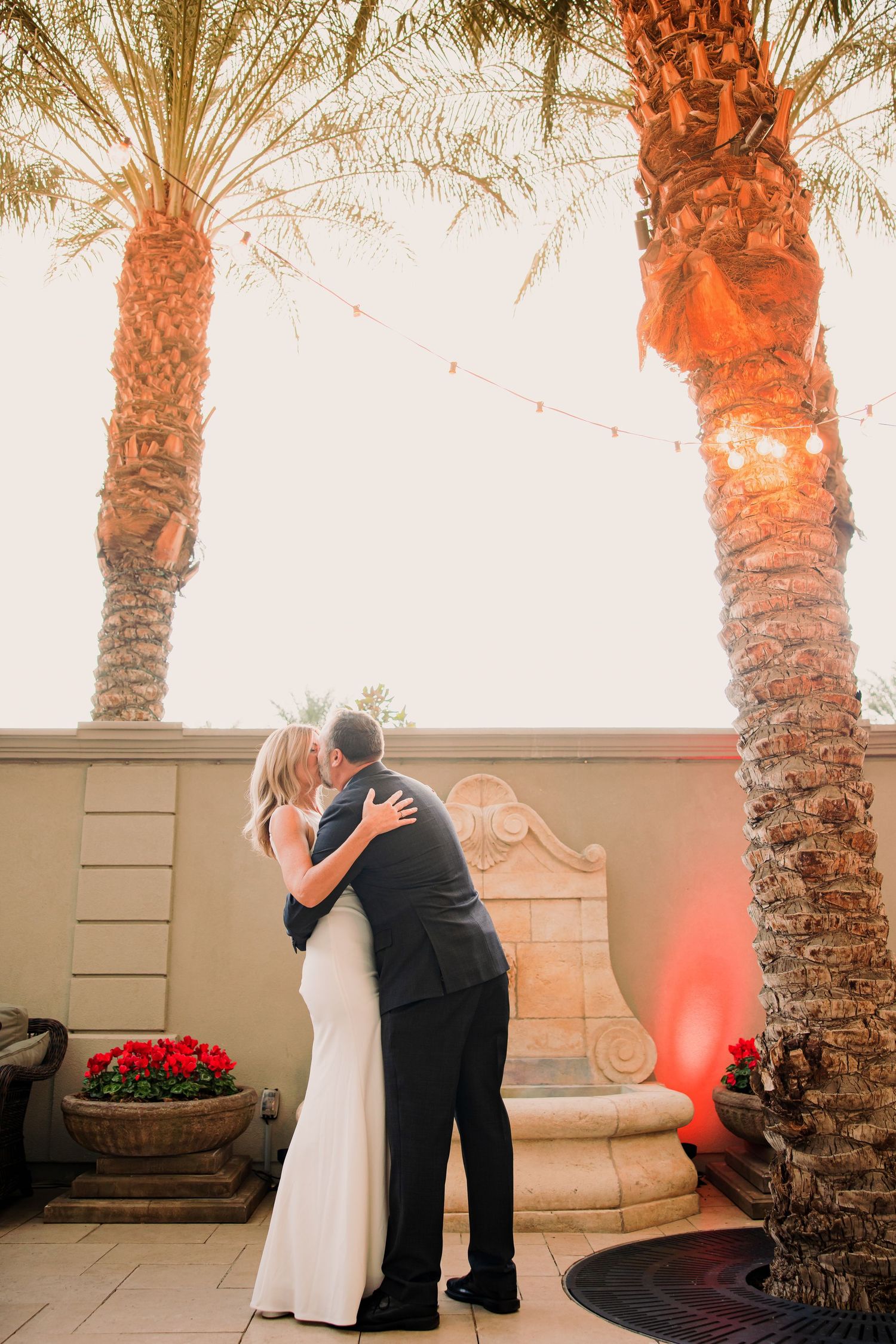 A romantic sequence of dance poses under palm trees at sunset with warm lighting and elegant formal attire.