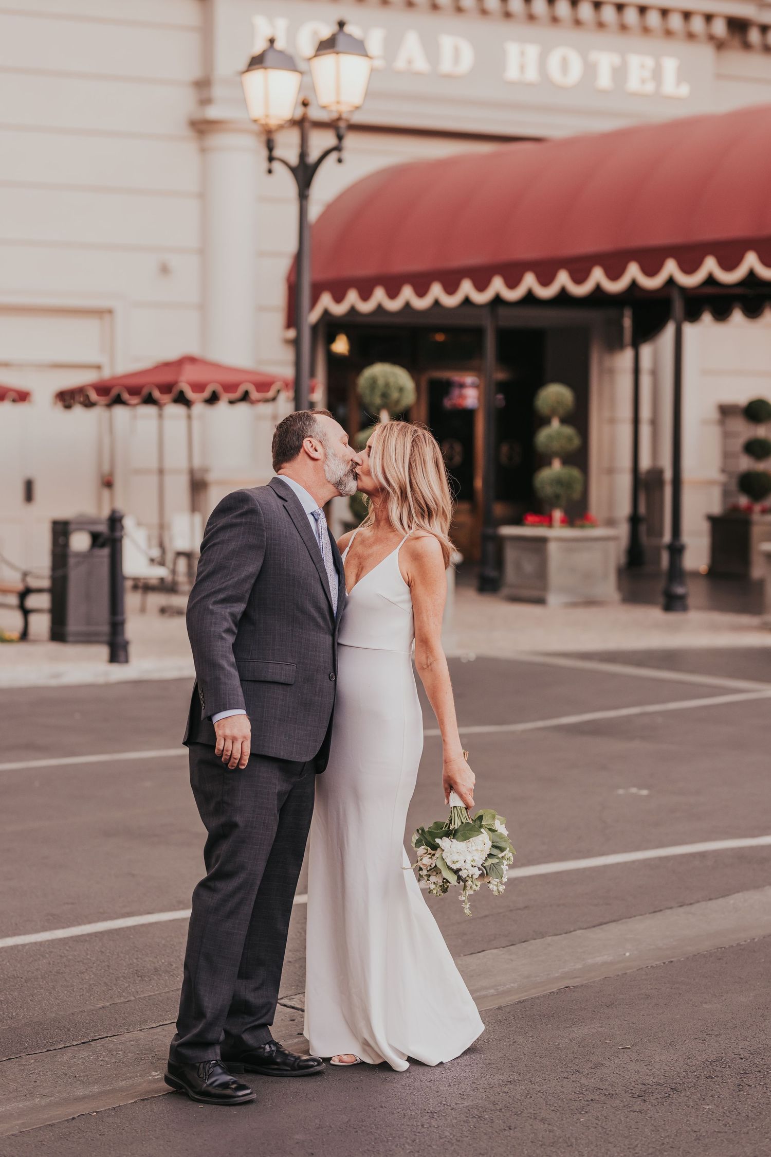 A romantic wedding sequence shows a couple in formal attire sharing tender moments outside a historic hotel building.