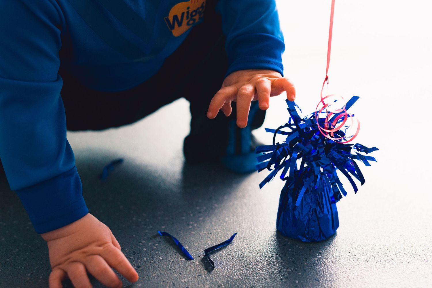 Close-up view of hands holding blue and orange pom poms during a cheerleading or sports performance.