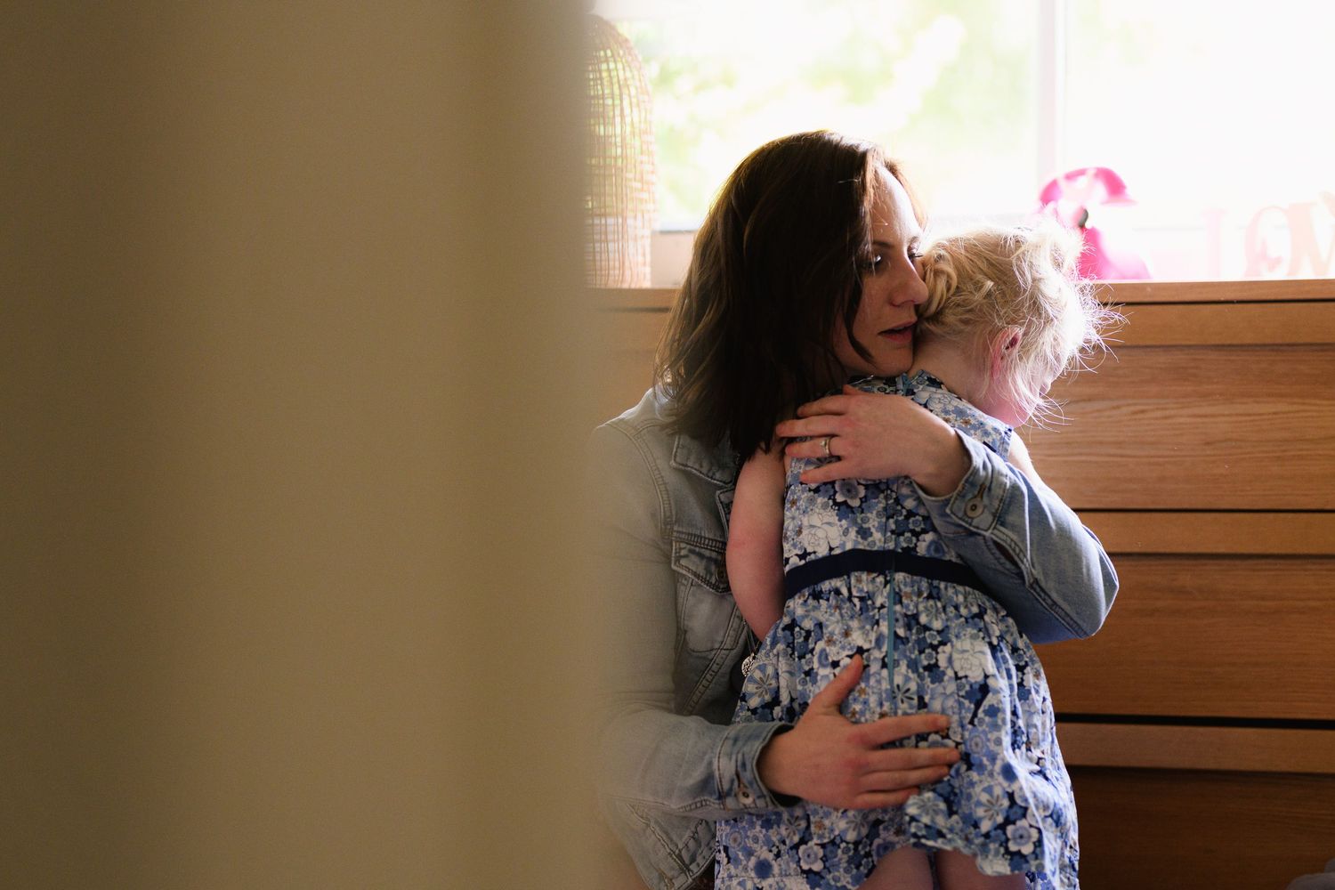 A sequence of images showing a warm embrace between two people in front of a wooden wall.