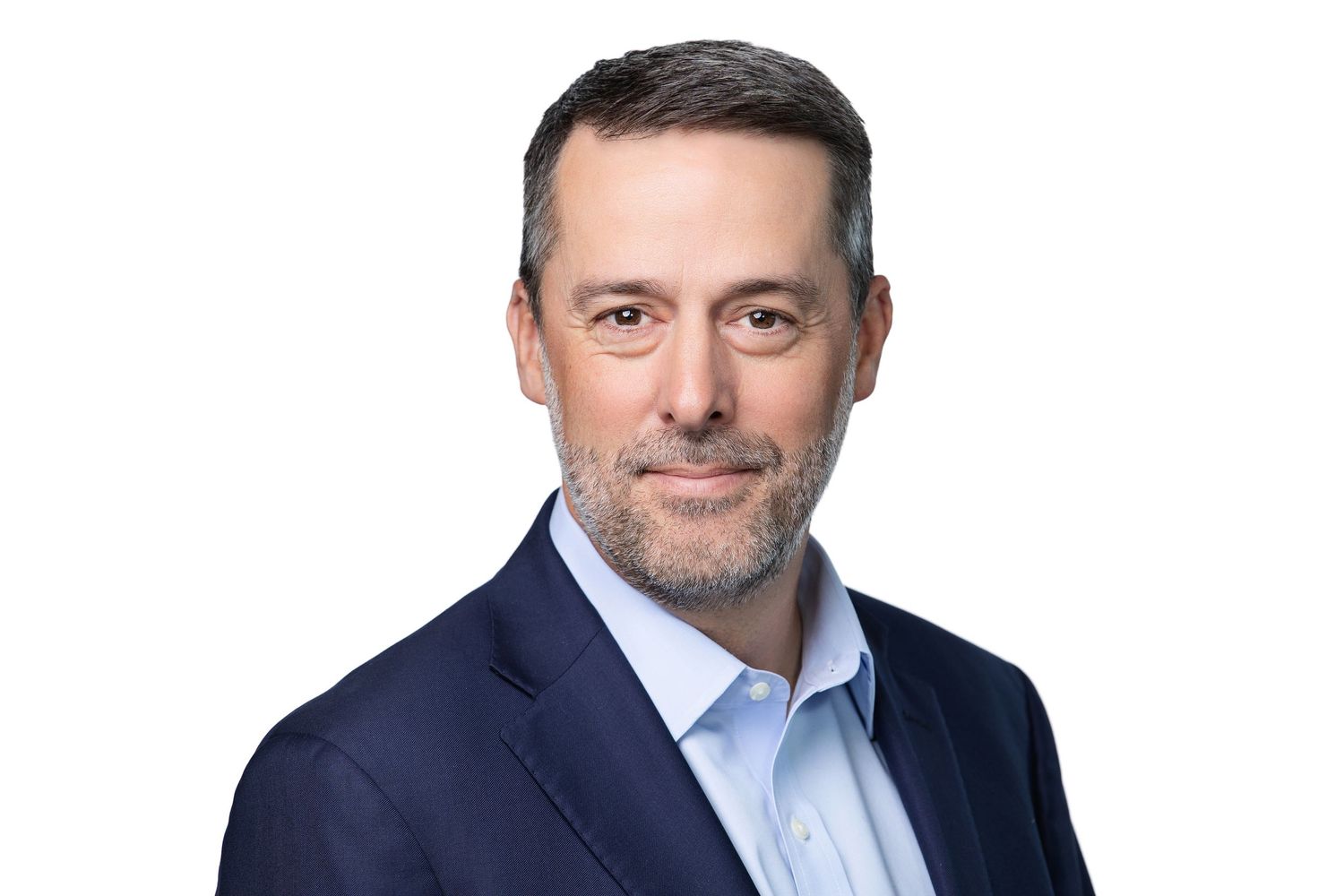 Professional headshot of someone wearing a navy blazer and light blue dress shirt against white background.
