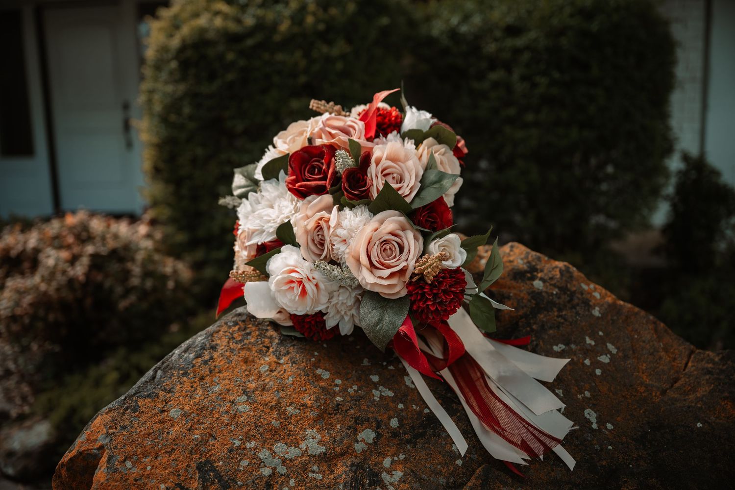 Romantic bridal bouquet in Dallas–Fort Worth with white, pastel pink and deep red roses with matching ribbons. Willow Creek Wedding Venue