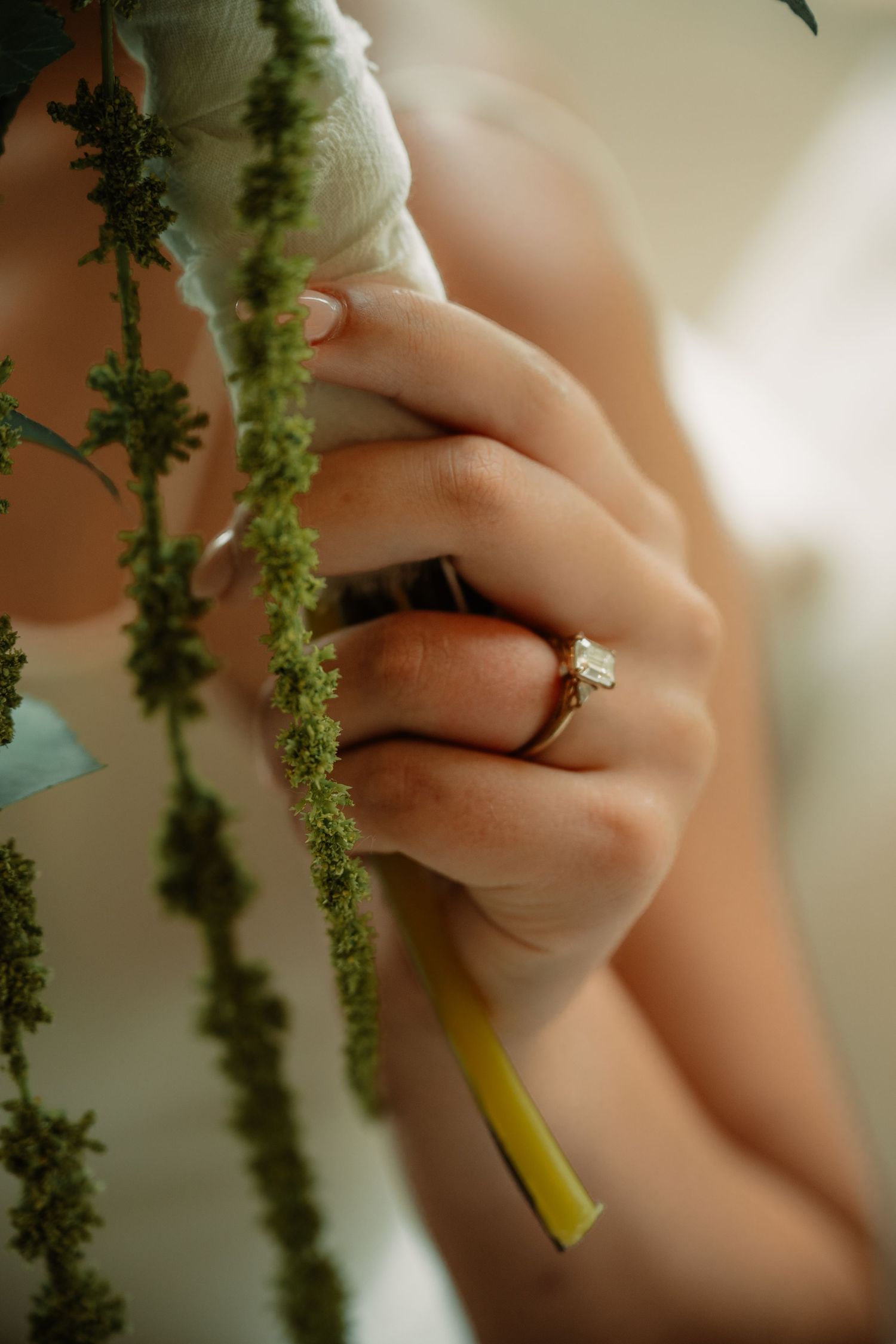 Bridal wedding bouquet and ring portrait with hanging green florals at the Hillside Estate in Dallas, Texas