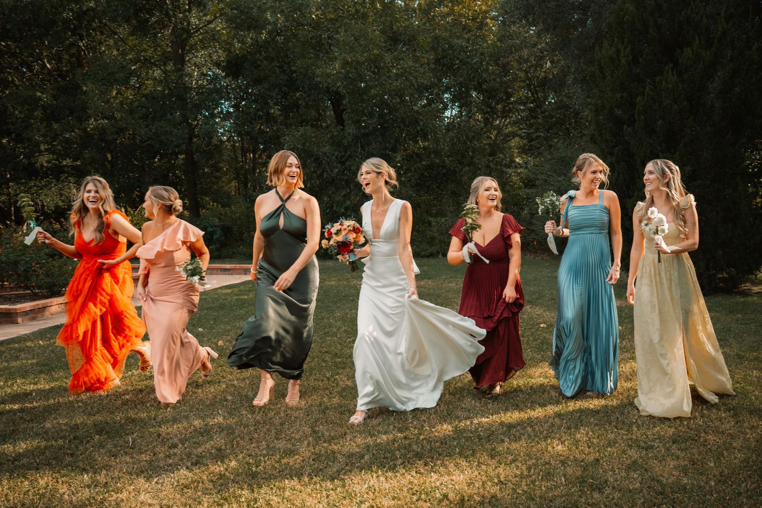 Lifestyle wedding portraits in Weatherford Texas of bridesmaids running and laughing together in Clark Gardens