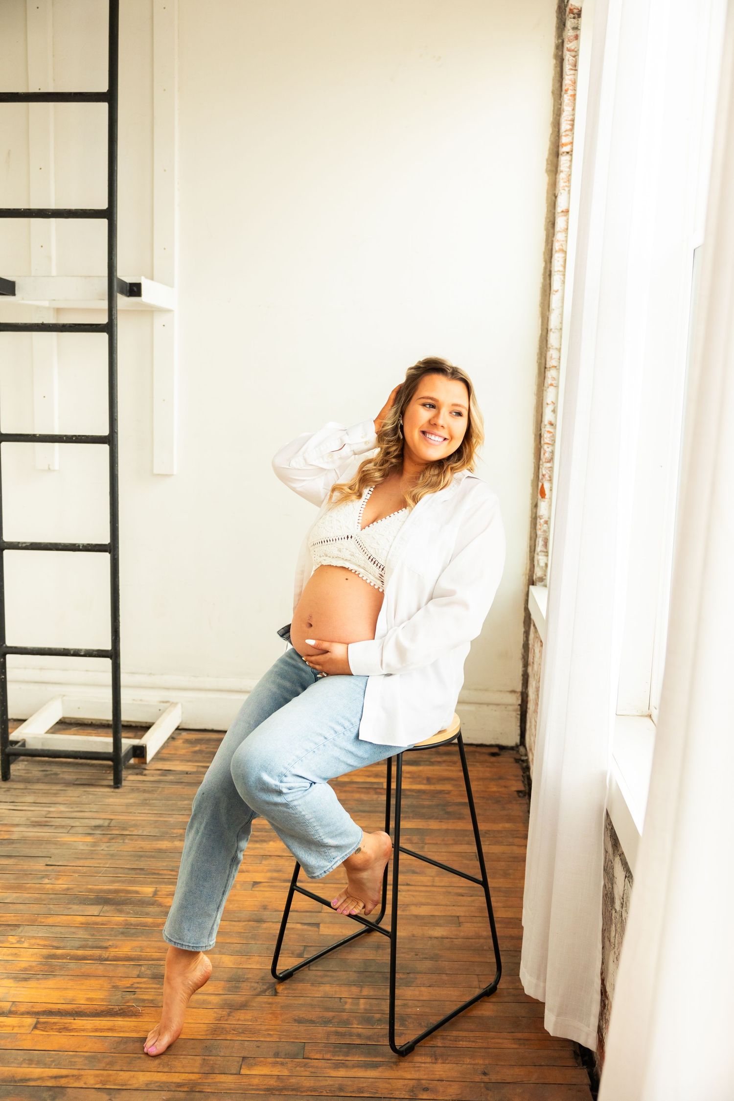 A series of candid studio photos showing a casual pose progression on a wooden floor against a white wall.