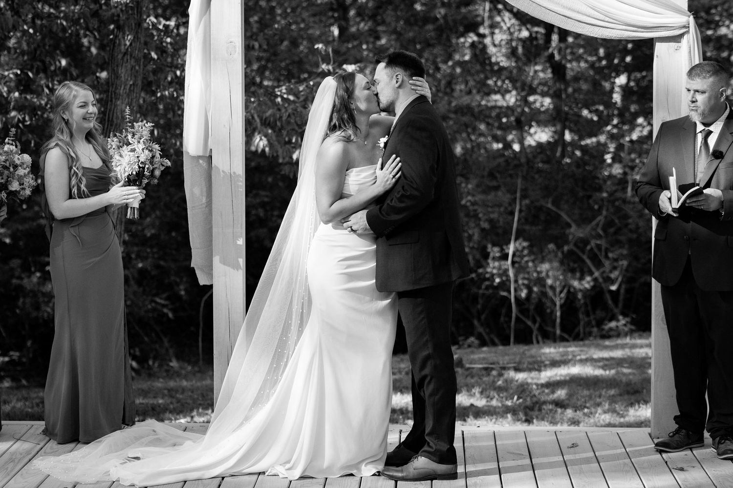 Bride and groom share their first kiss during an outdoor wedding ceremony at the Henry Manor in Lancaster, Ohio.