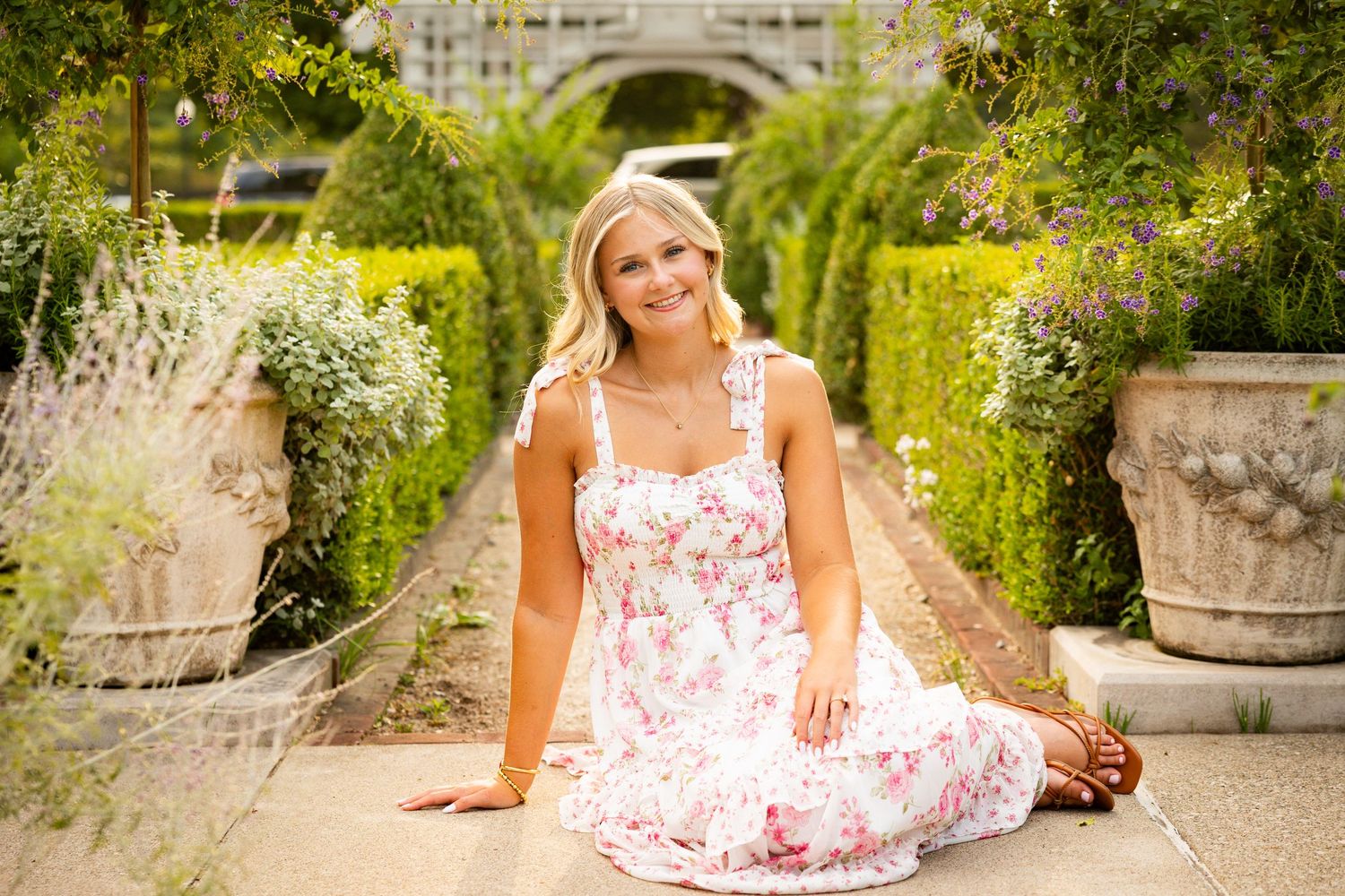 A series of images showing someone in a floral summer dress sitting on decorative garden steps by stone planters.