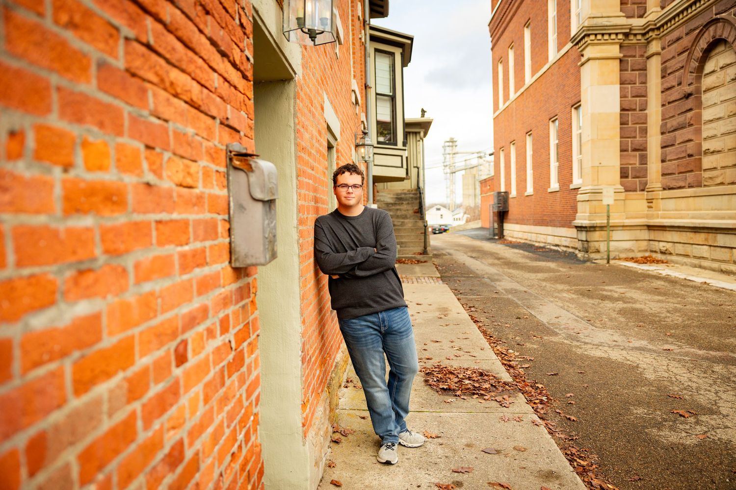 A series of brick wall portraits showing someone in casual attire posing against an orange brick wall background.