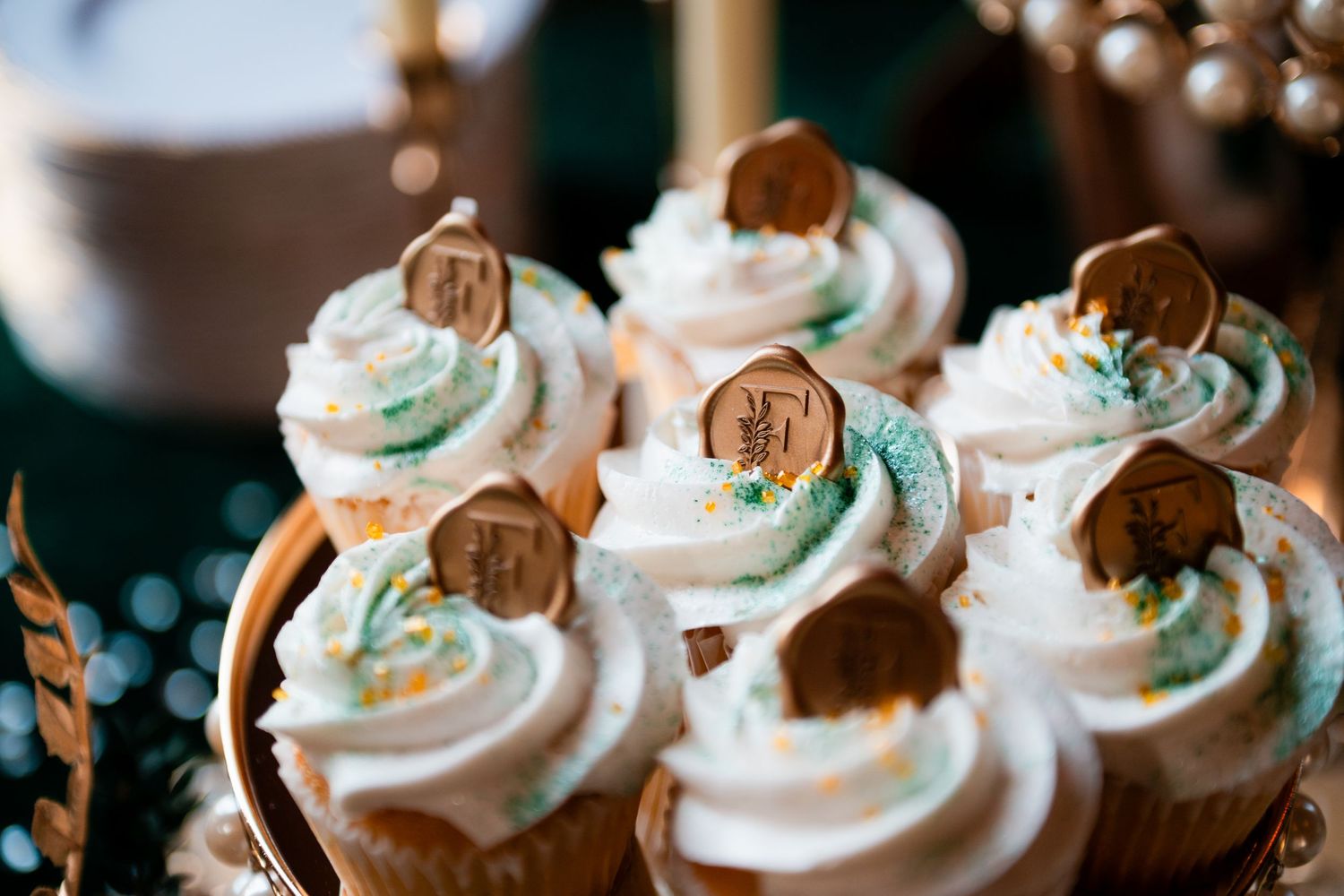 Chocolate cupcakes topped with swirled white frosting and small cookie decorations on a dessert display.