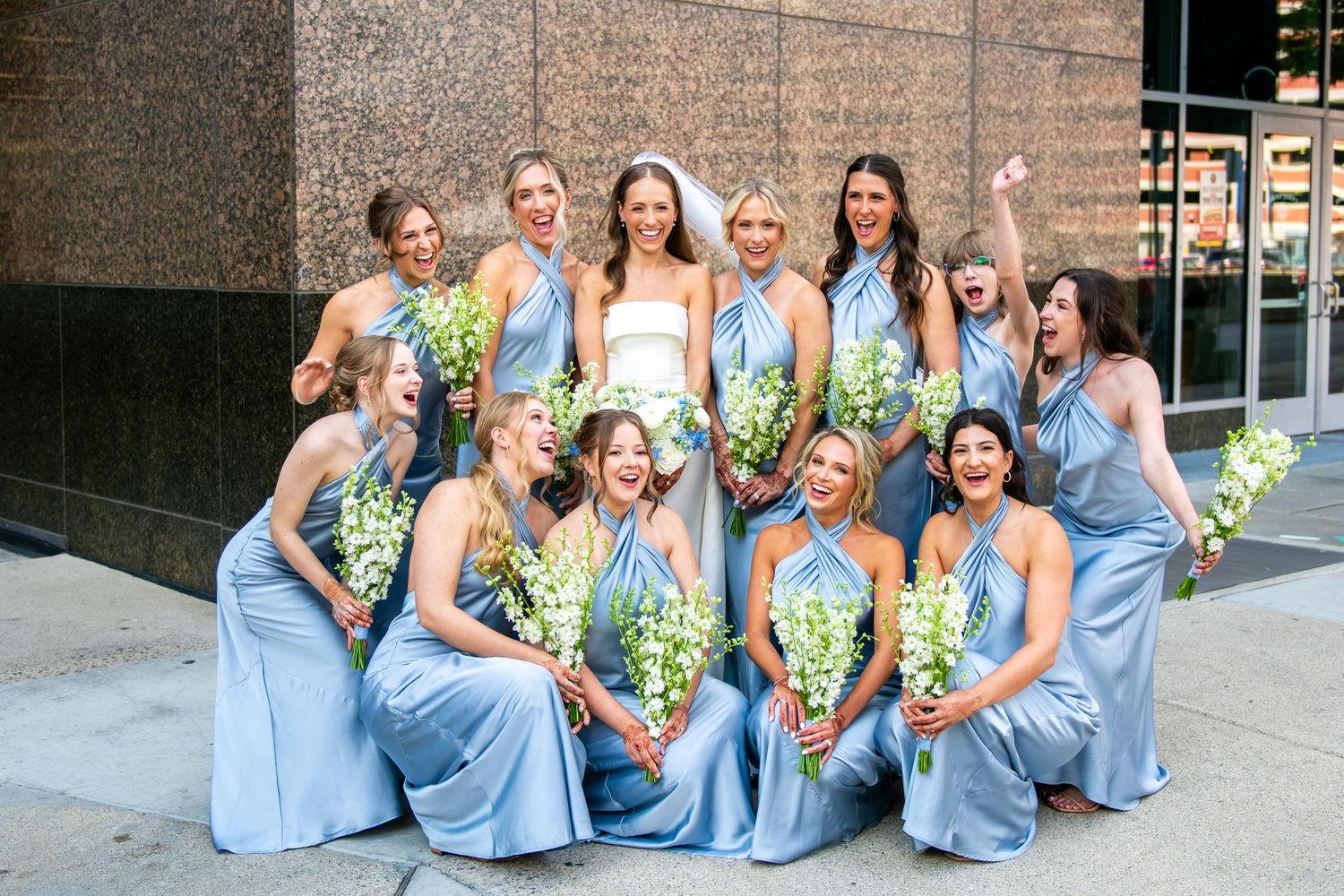 Bridesmaids in light blue dresses pose together with colorful bouquets in a series of outdoor wedding photos.