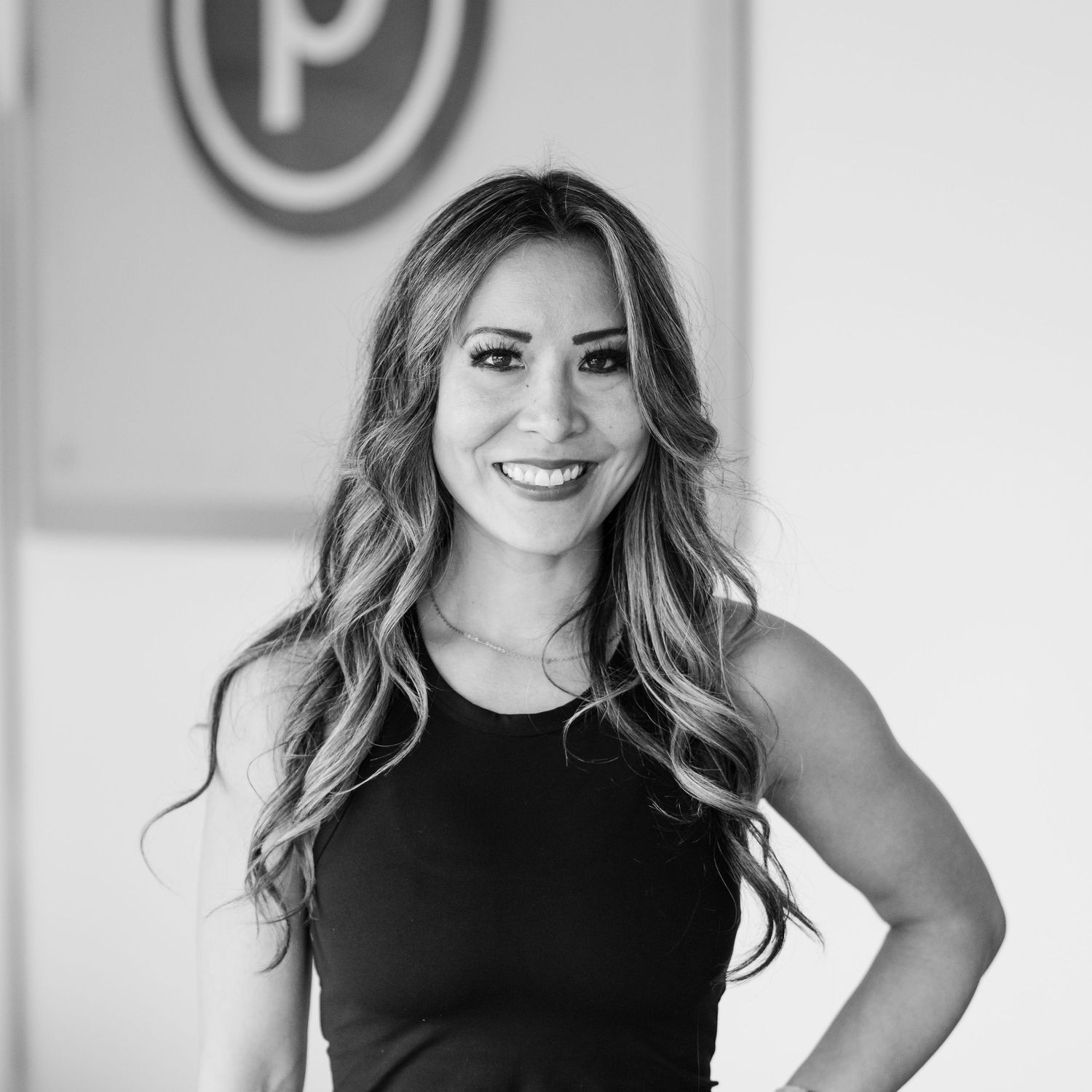 Professional black and white headshot showing confident poses of a fitness instructor in sleeveless top against light background.